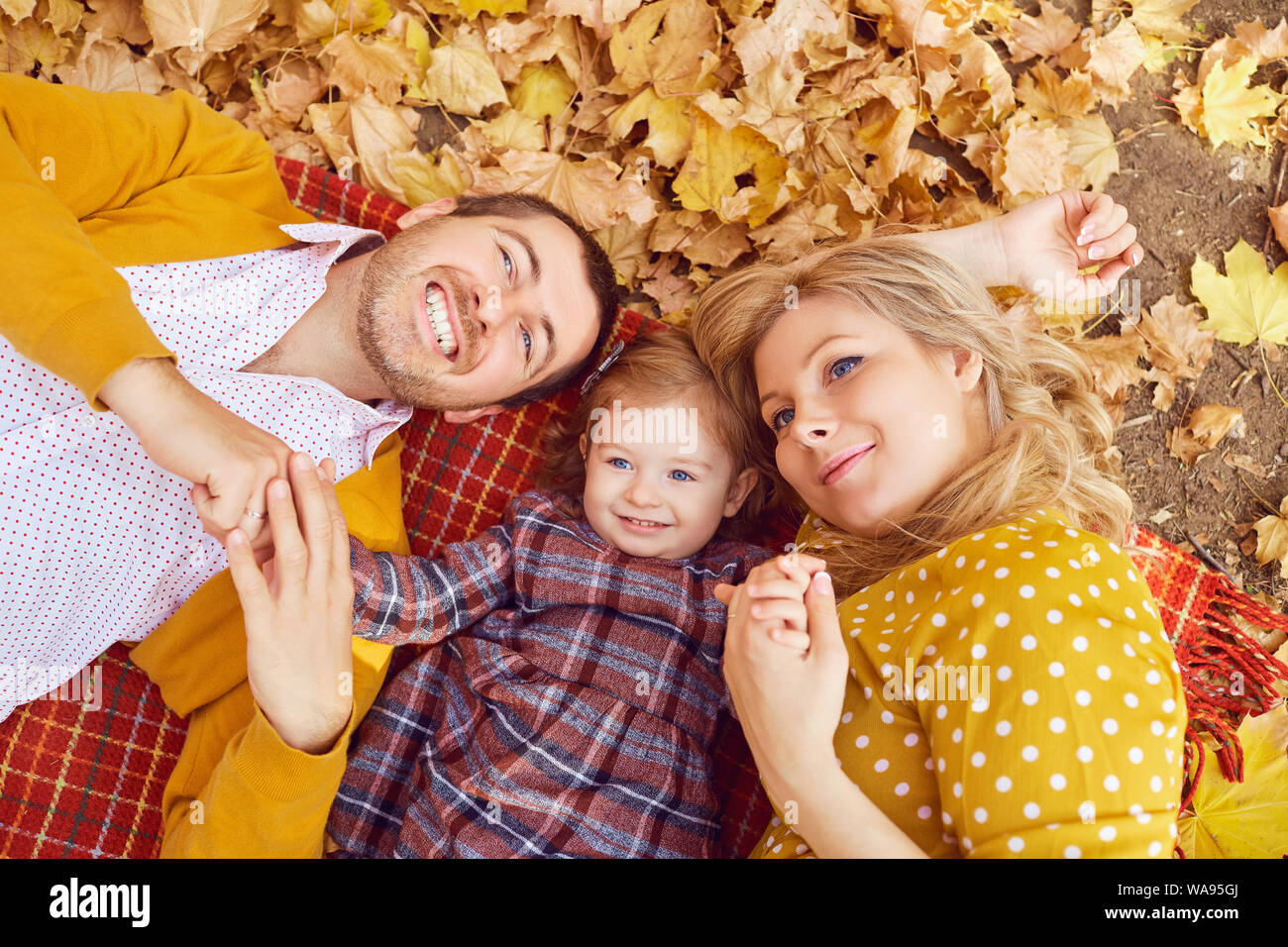 Famille heureuse étendu dans le parc en automne. Banque D'Images