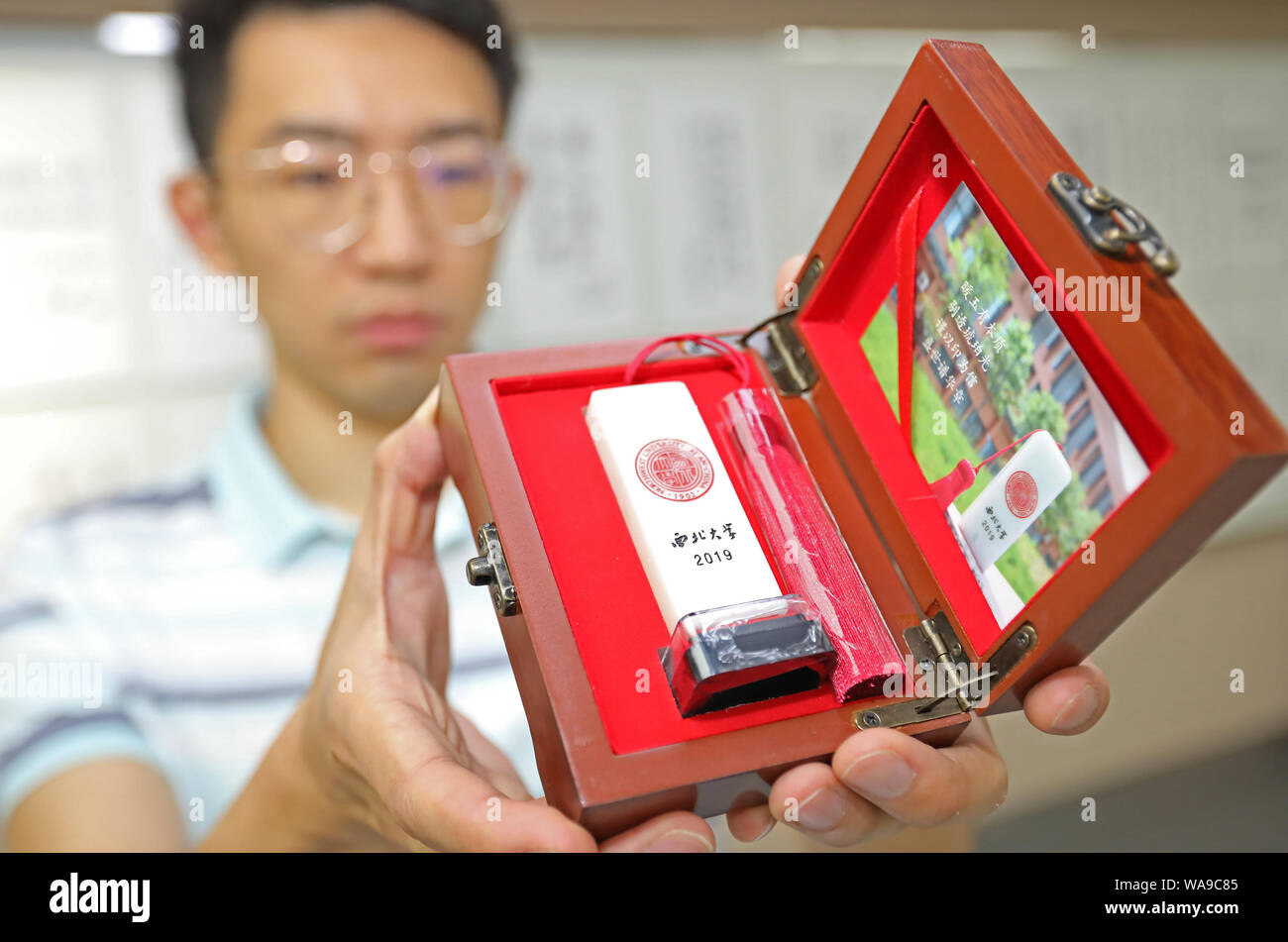 Un étudiant avancé montre son timbre sur mesure comme le cadeau de graduation spéciale à l'Université du nord-ouest de la ville de Xi'an, province du Shaanxi du nord-ouest de la Chine Banque D'Images