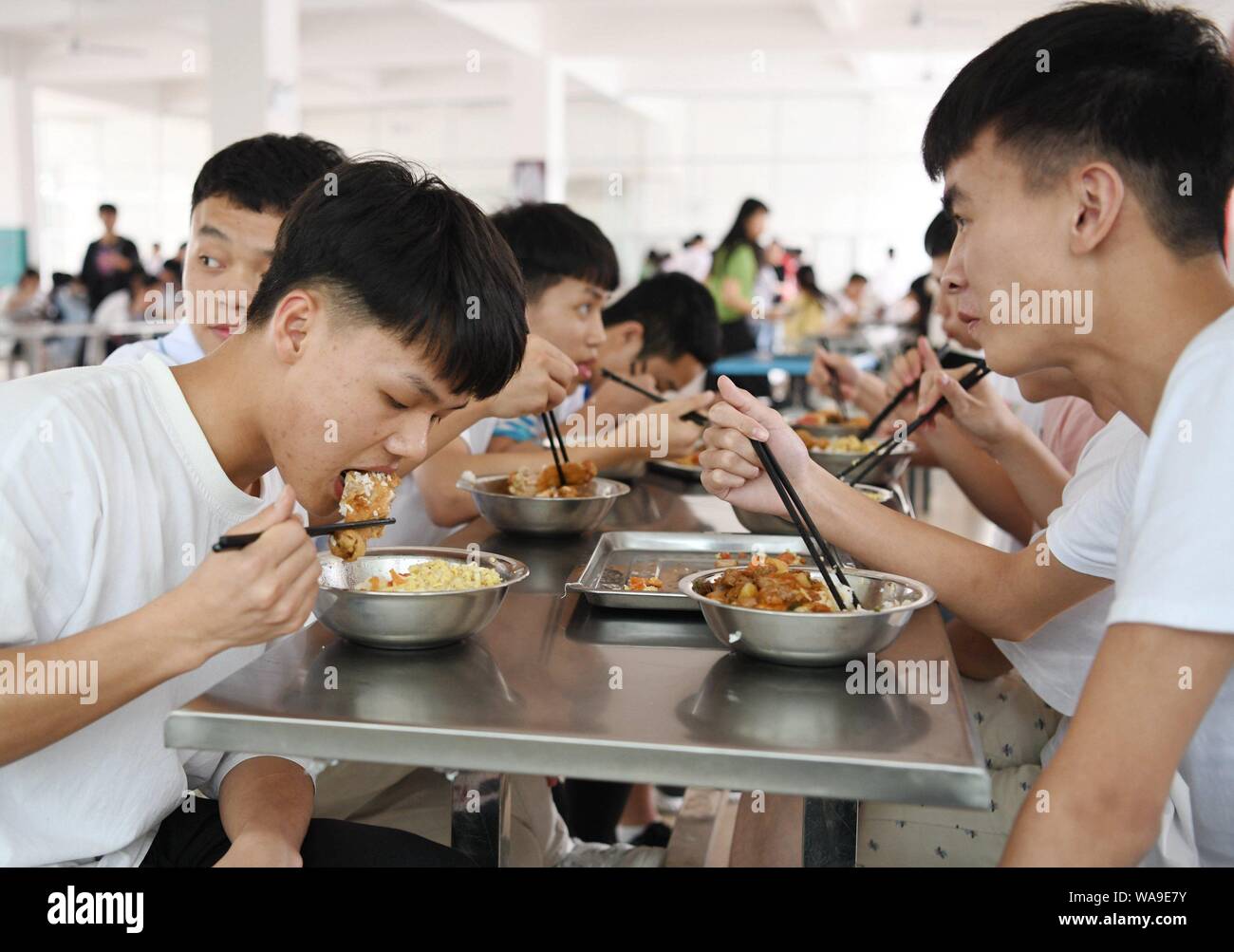 Des étudiants chinois, déjeuner à la cantine à un senior high school à Linyi Mulam comté autonome de la Chine du Sud, région autonome Zhuang du Guangxi, Banque D'Images