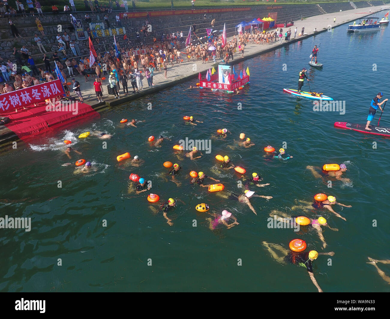 Les participants ont la concurrence dans un défi de natation pour nager dans la rivière Han, un affluent de la rivière Yangtze, dans la ville de Xiangyang, le centre de la Chine, Shanghai Banque D'Images