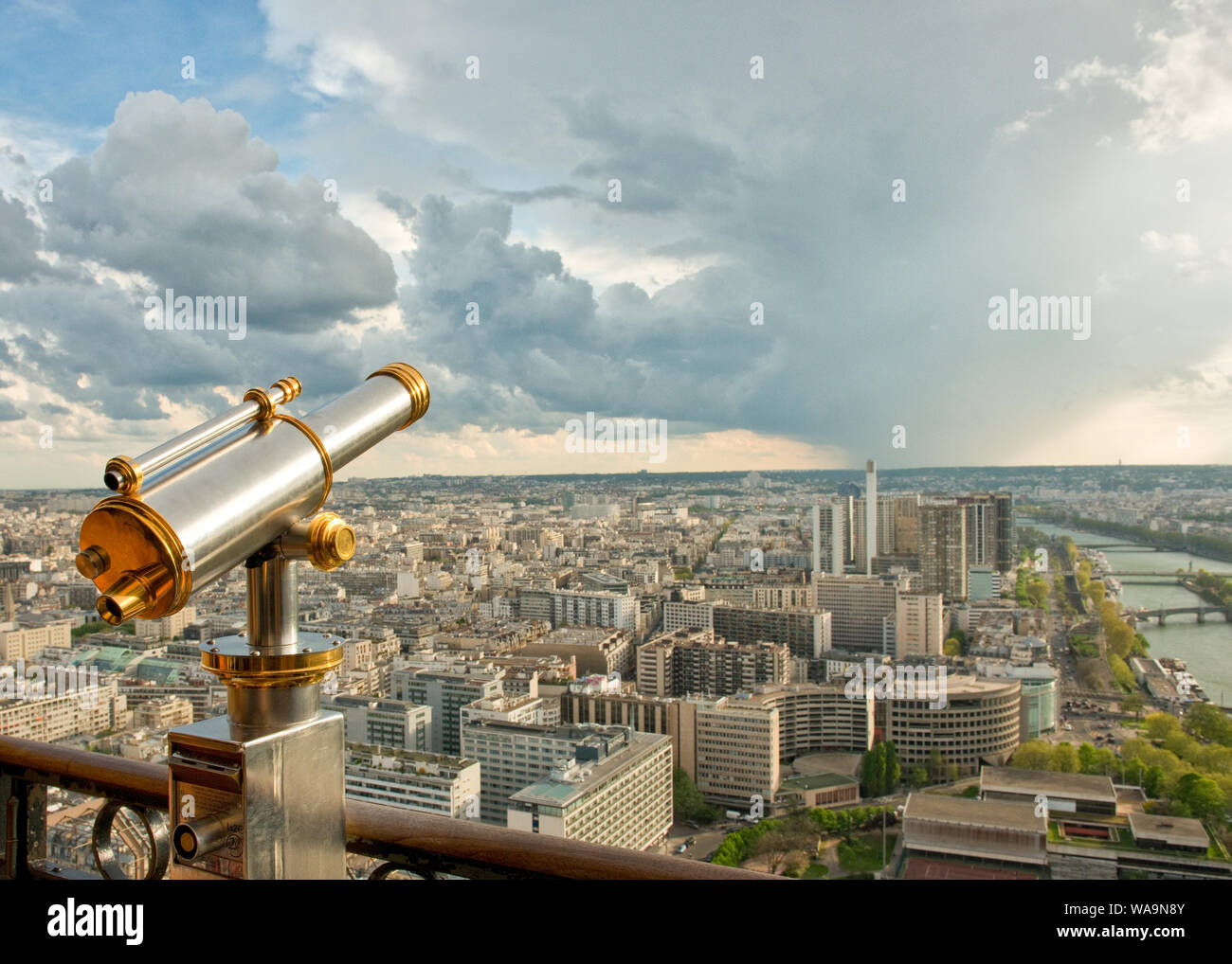 Un télescope sur la Tour Eiffel plate-forme d'observation. En regardant vers le sud-ouest le long de la Seine et d'une douche à effet pluie nuages. Paris, France Banque D'Images