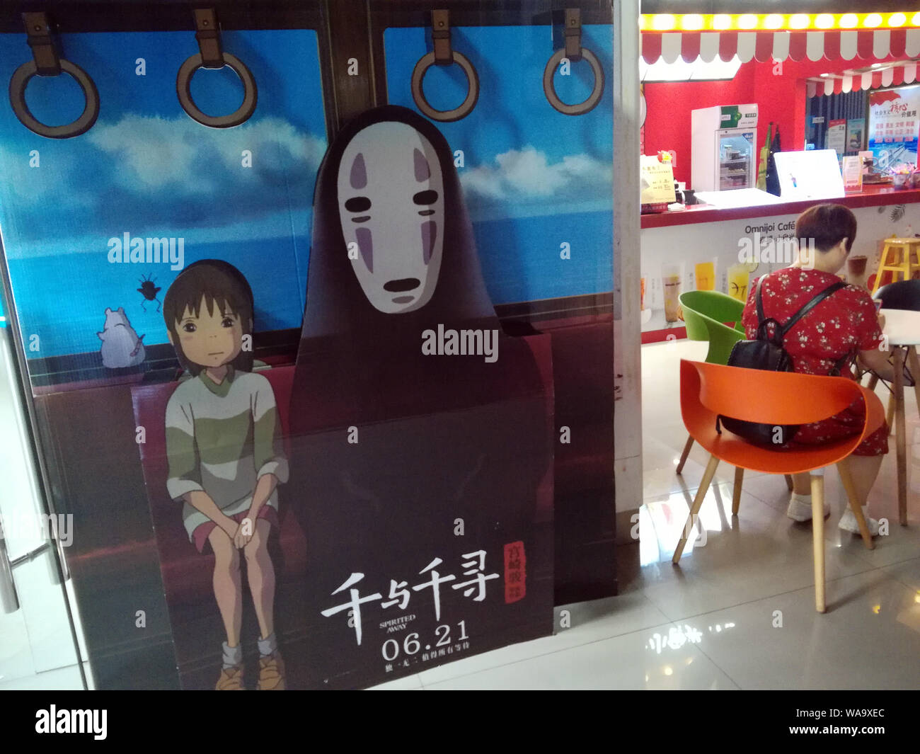 --FILE--une filmgoer attend à côté d'une affiche de film d'animation japonais 'spider' dans un cinéma à Yichang city, le centre de la Chine, la province du Hubei, 24 Jun Banque D'Images