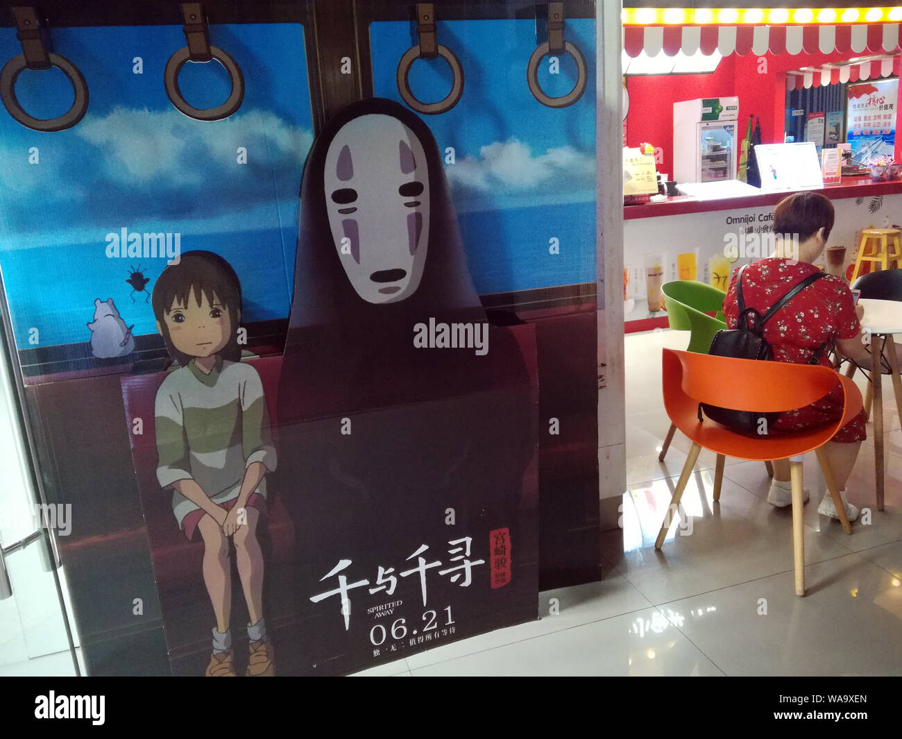 --FILE--une filmgoer attend à côté d'une affiche de film d'animation japonais 'spider' dans un cinéma à Yichang city, le centre de la Chine, la province du Hubei, 24 Jun Banque D'Images