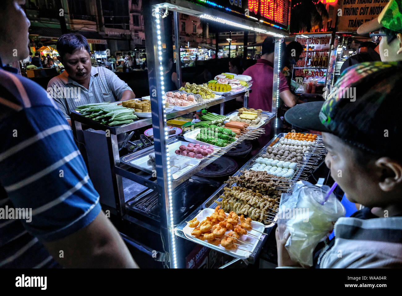 Can Tho, Vietnam - 11 Août : La vente des aliments de rue de l'homme vietnamiens sur le marché nocturne dans le Delta du Mékong, le 11 août 2018 à Can Tho, Vietnam. Banque D'Images