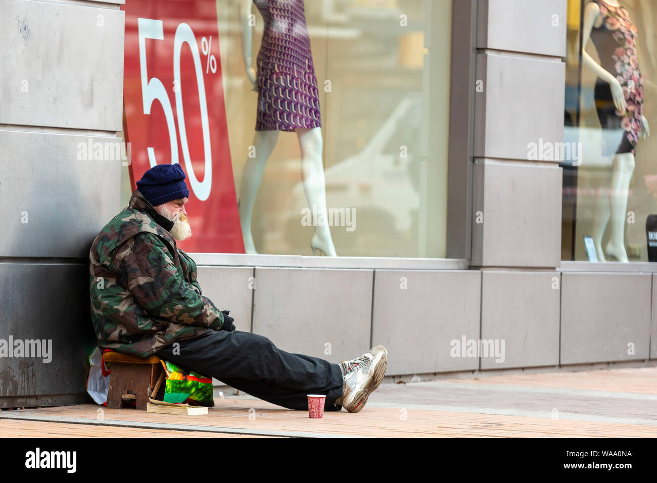 Sofia, Bulgarie - 22 janvier 2019 : personnes âgées sans abri l'homme implore pour argent en face d'un magasin de vêtements à du boulevard Vitosha à Sofia. Banque D'Images