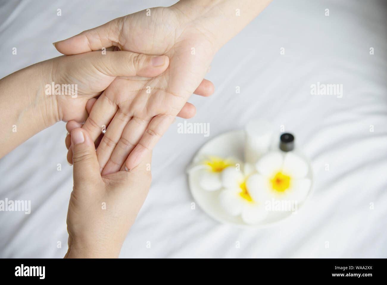 Côté spa massage sur lit blanc propre contexte - les gens vous détendre avec des massages à la main Banque D'Images