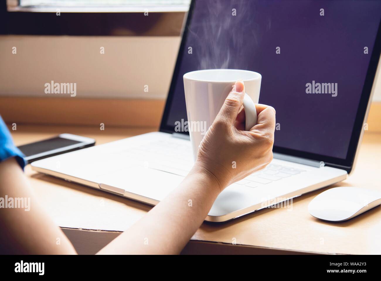 Femme travaillant à l'ordinateur avec une tasse à café dans la chambre d'hôtel - personnes travaillant concept de vie Banque D'Images