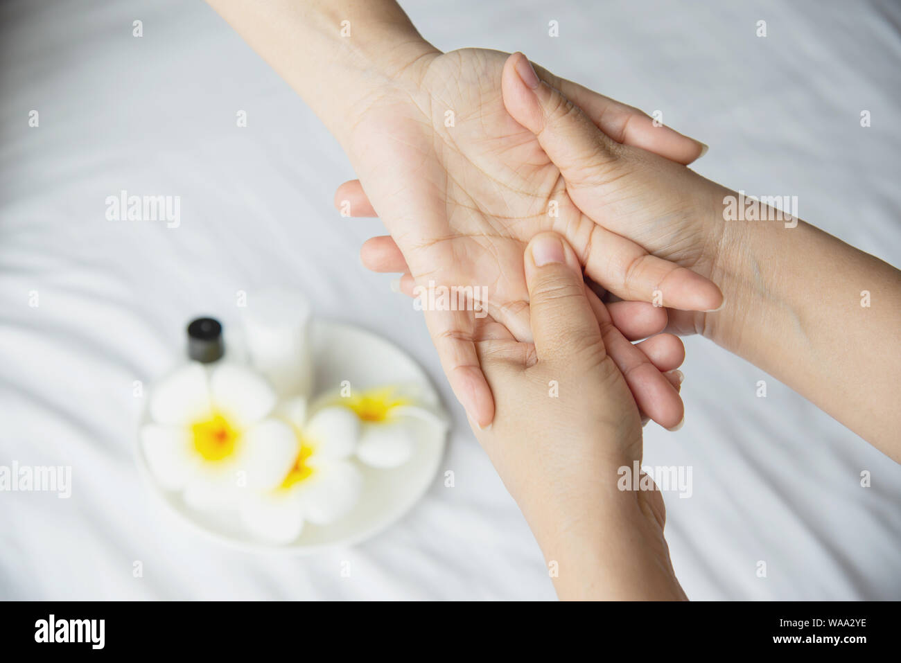 Côté spa massage sur lit blanc propre contexte - les gens vous détendre avec des massages à la main Banque D'Images