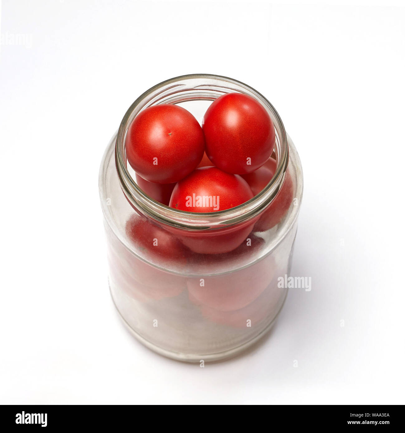 La mise en conserve maison de tomates rouges, les tomates dans un bocal en verre sur un fond blanc Banque D'Images