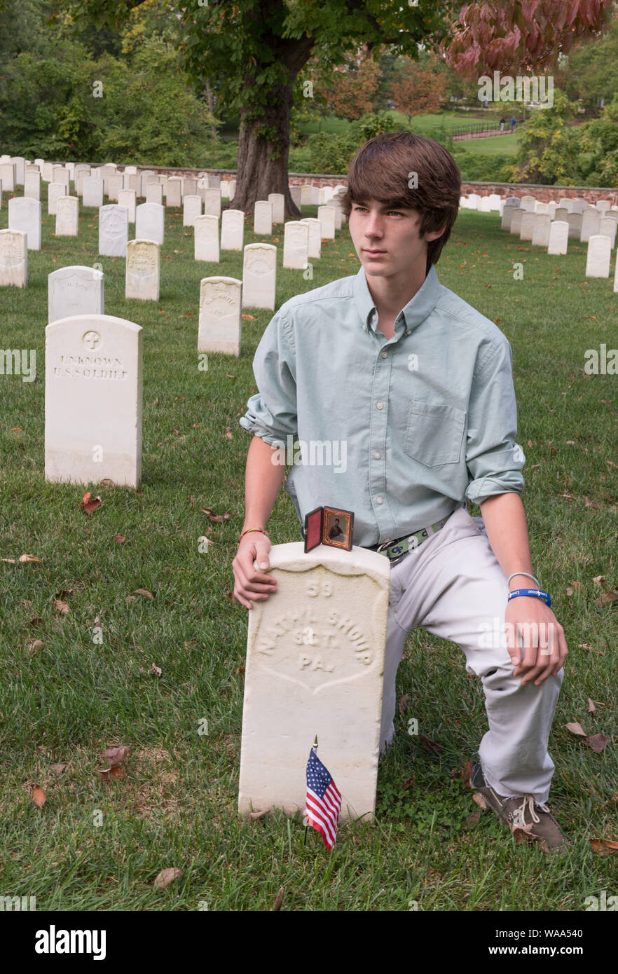 Christian Liljenquist pose à la tombe d'un soldat (Nath'l Shoup, Sgt. Pa.) qui sont morts pendant la guerre civile. Un ambrotype photo de Shoup est sur le dessus de la pierre tombale. Le Cimetière National d'Alexandria, Alexandria, Virginia Résumé : Avant l'Liljenquist a fait don de la famille de Nathaniel photo ambrotype Shoup pour la Bibliothèque du Congrès, ils ont pris la photo de la tombe de Shoup site. Shoup meurt de fièvre typhoïde en 1862 alors qu'il était membre du 84e Régiment d'infanterie de Pennsylvanie. Pour regarder de plus près, voir le portrait de Shoup AMB/étain no. 3032, http://hdl.loc.gov/loc.pnp/ppmsca.34377 Banque D'Images
