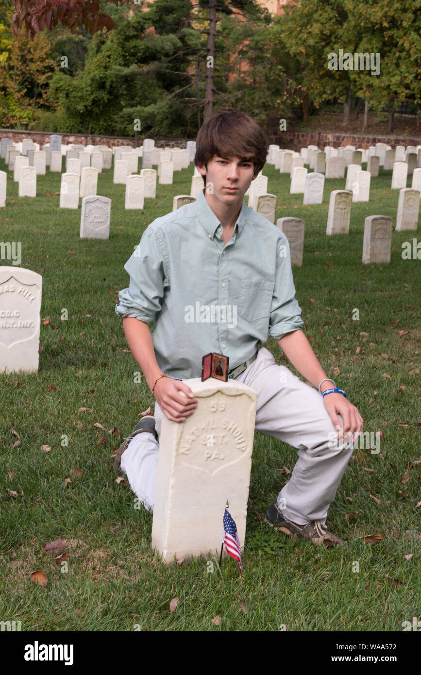 Christian Liljenquist pose à la tombe d'un soldat (Nath'l Shoup, Sgt. Pa.) qui sont morts pendant la guerre civile. Un ambrotype photo de Shoup est sur le dessus de la pierre tombale. Le Cimetière National d'Alexandria, Alexandria, Virginia Résumé : Avant l'Liljenquist a fait don de la famille de Nathaniel photo ambrotype Shoup pour la Bibliothèque du Congrès, ils ont pris la photo de la tombe de Shoup site. Shoup meurt de fièvre typhoïde en 1862 alors qu'il était membre du 84e Régiment d'infanterie de Pennsylvanie. Pour regarder de plus près, voir le portrait de Shoup AMB/étain no. 3032, http://hdl.loc.gov/loc.pnp/ppmsca.34377 Banque D'Images