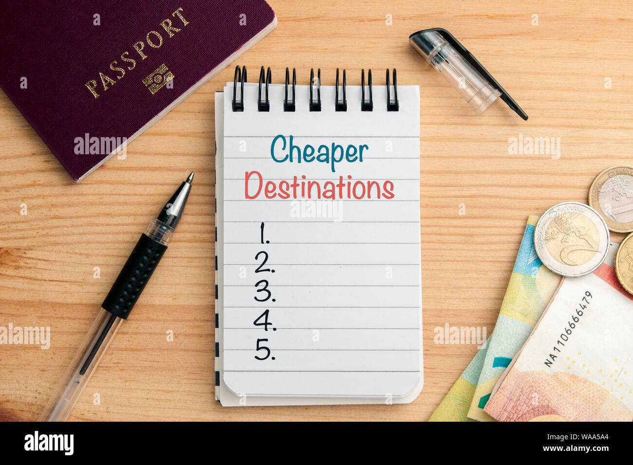 Enregistrement de voyager concept : un bloc-notes avec copyspace liste de destinations moins chères sur table en bois avec un stylo, un passeport et un peu d'argent Banque D'Images