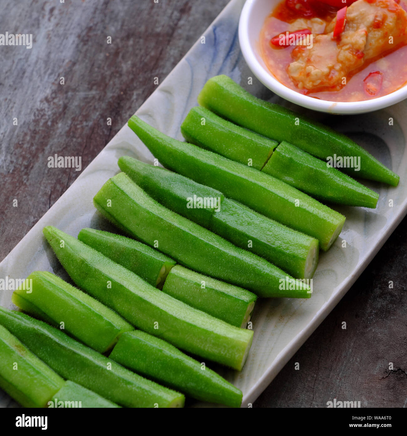 Vue du dessus de la plaque rectangle de gombo bouilli avec du fromage ou du tofu Le tofu fermenté sur fond de bois, cette légumes bon pour la santé par la vitamine, l'acide folique Banque D'Images