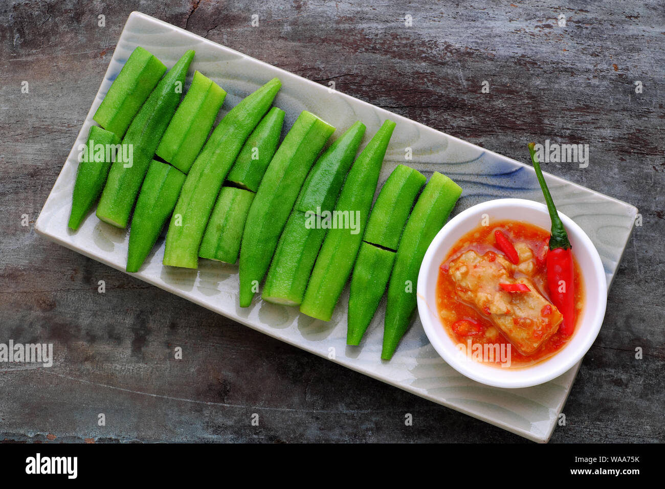 Vue du dessus de la plaque rectangle de gombo bouilli avec du fromage ou du tofu Le tofu fermenté sur fond de bois, cette légumes bon pour la santé par la vitamine, l'acide folique Banque D'Images