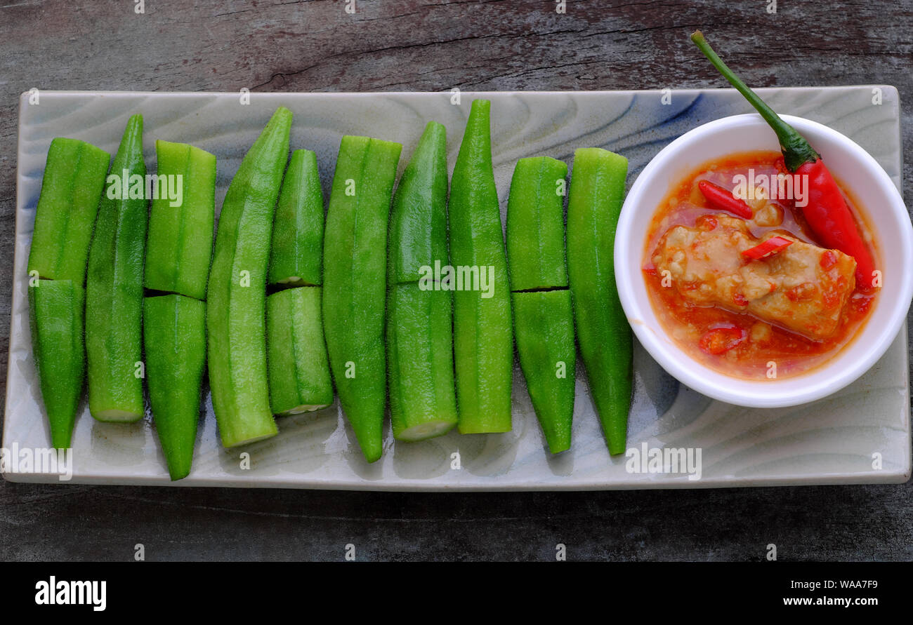 Vue du dessus de la plaque rectangle de gombo bouilli avec du fromage ou du tofu Le tofu fermenté sur fond de bois, cette légumes bon pour la santé par la vitamine, l'acide folique Banque D'Images