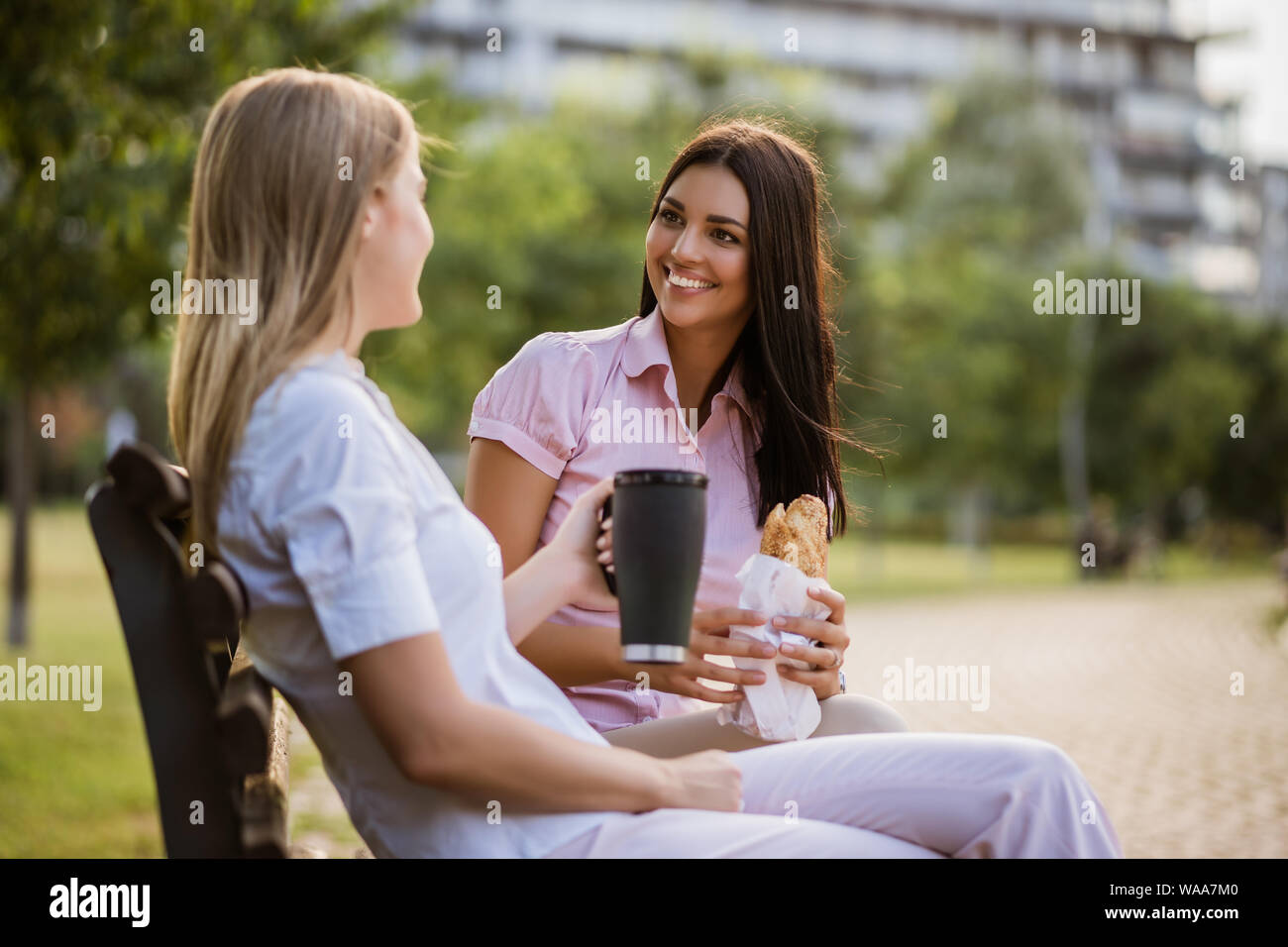 Deux collègues sont assis dans un parc et de parler pendant la pause. Banque D'Images
