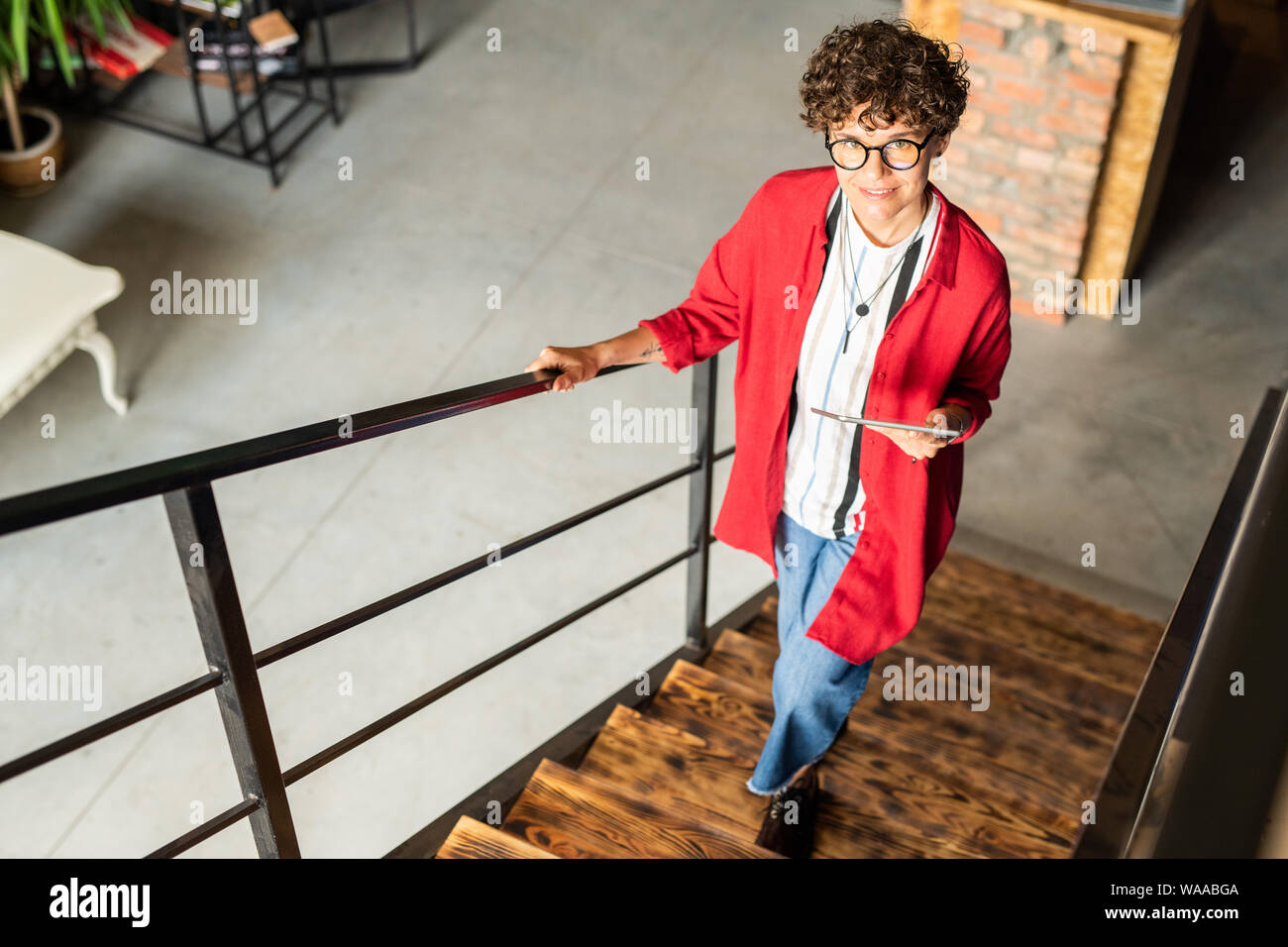 Les jeunes de la mode élégante desigher déménagement l'étage et vous regarde Banque D'Images