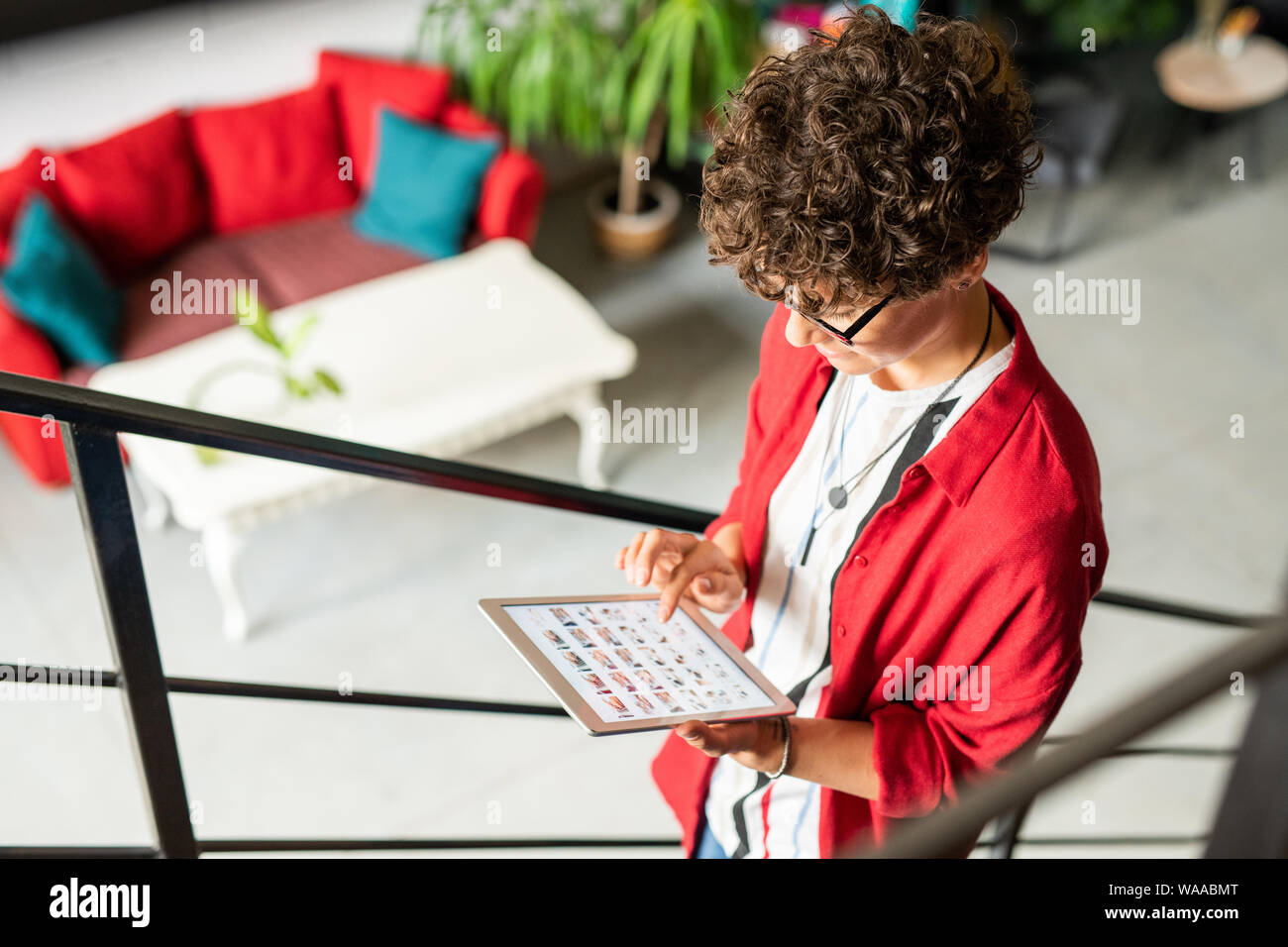 Jeune créateur de mode créative le défilement en comprimé sur sa façon de travail Banque D'Images