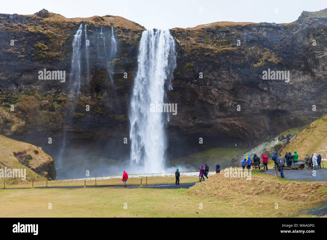 Reykjavik, Islande - 5 Avril 2017 : les touristes à pied près de Seljalandfoss, cascade naturelle la populaires de la nature islandaise Banque D'Images