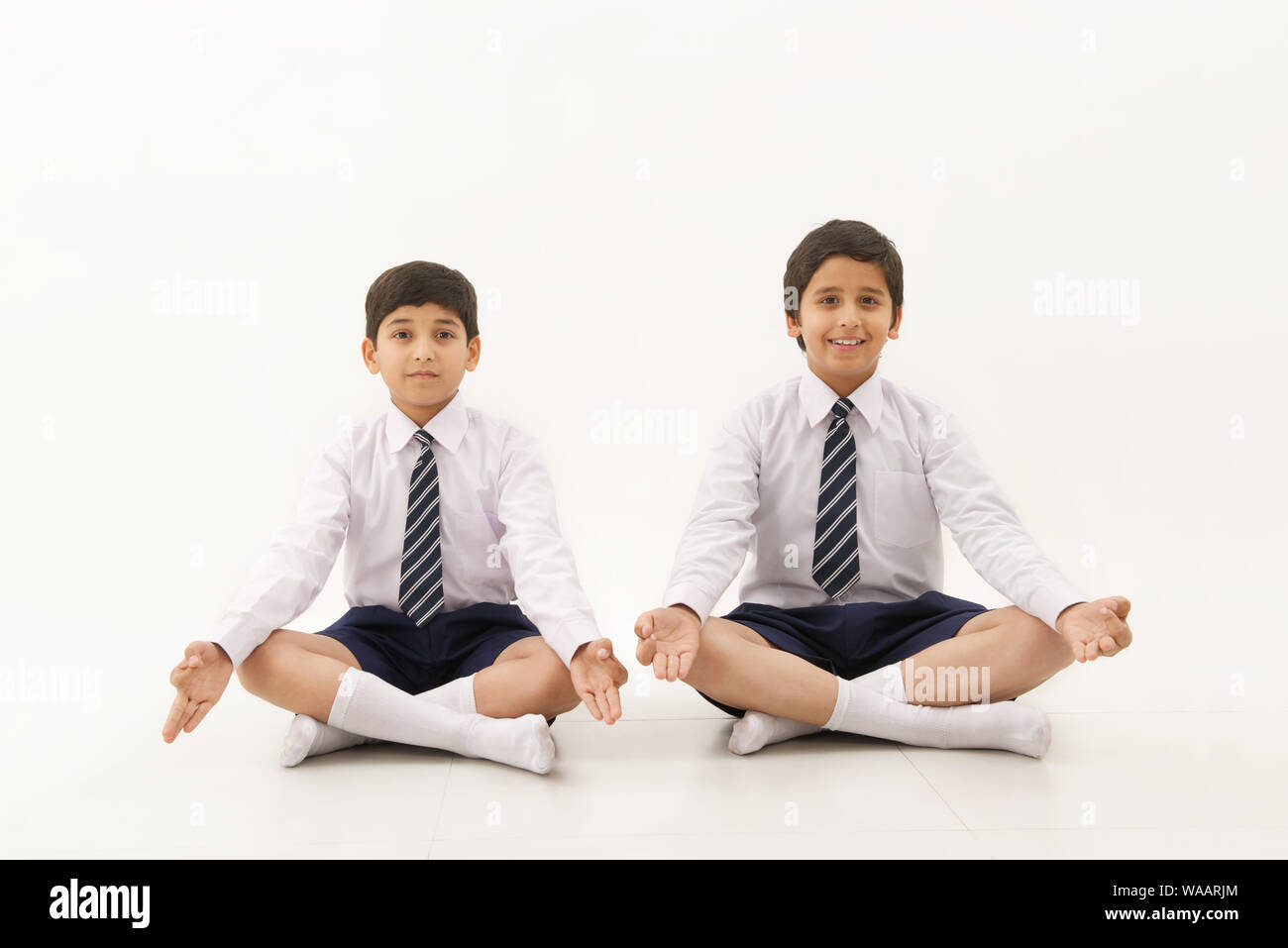 Collégiens assis dans yoga pose Banque D'Images