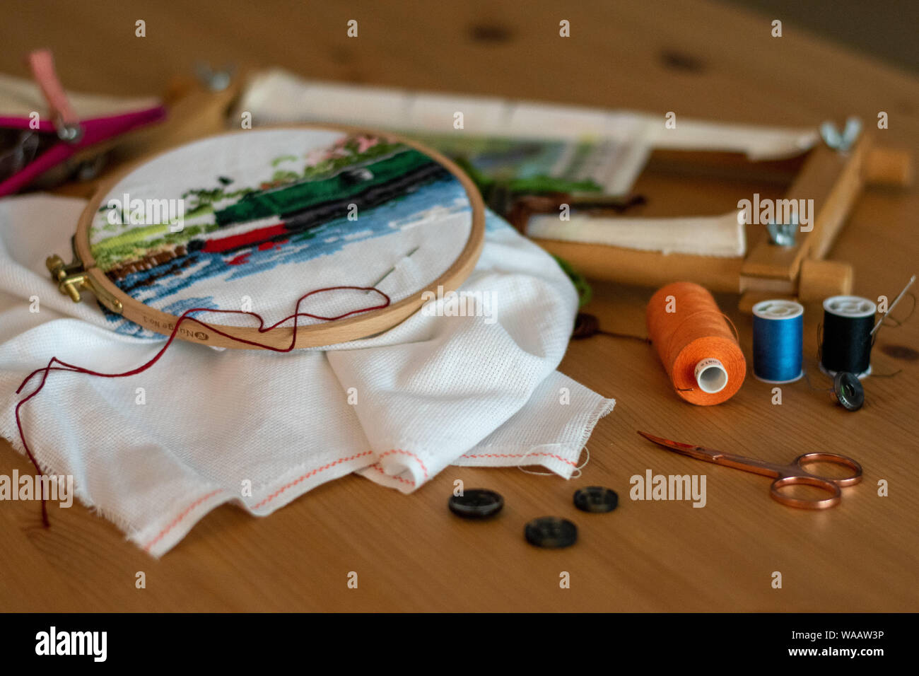 Broderie au point de croix, matériaux, y compris les fils, aiguilles, ciseaux, , et cerceaux. disposés sur une table pour l'artisanat/hobby Banque D'Images