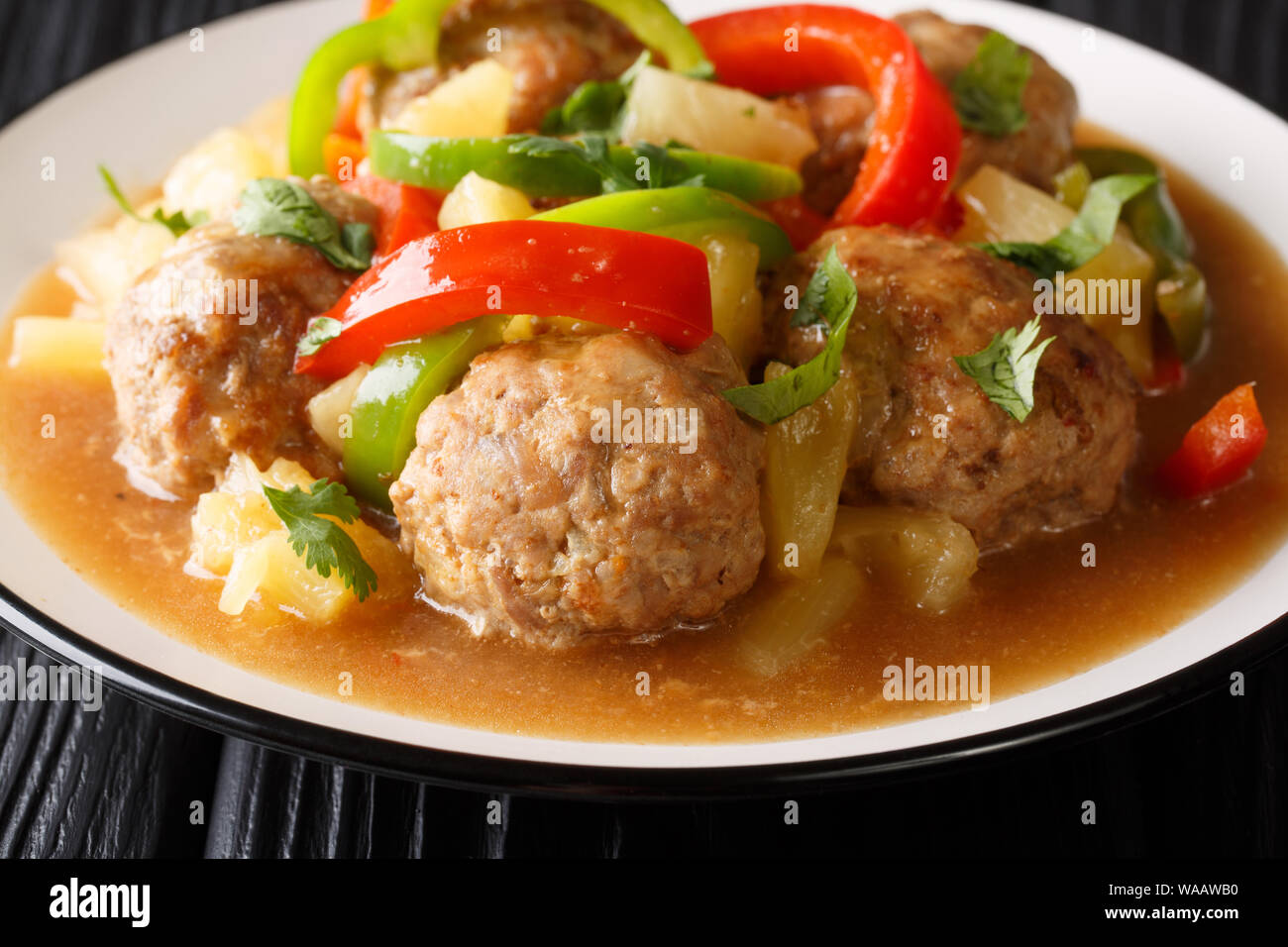 Servir les boulettes avec de l'ananas frais et poivrons dans une sauce aigre-douce close-up sur une plaque sur la table horizontale. Banque D'Images