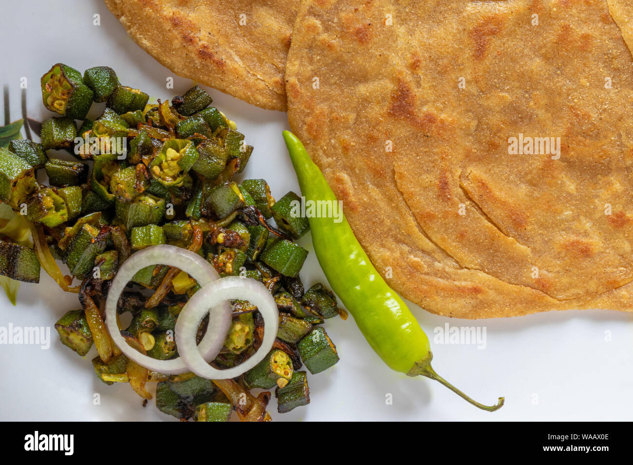 Lachha, blé entier Paratha Placez le pain plat en couches avec Bhindi Masala (Lady finger) ou sabzi Bhaji ou recette. Banque D'Images