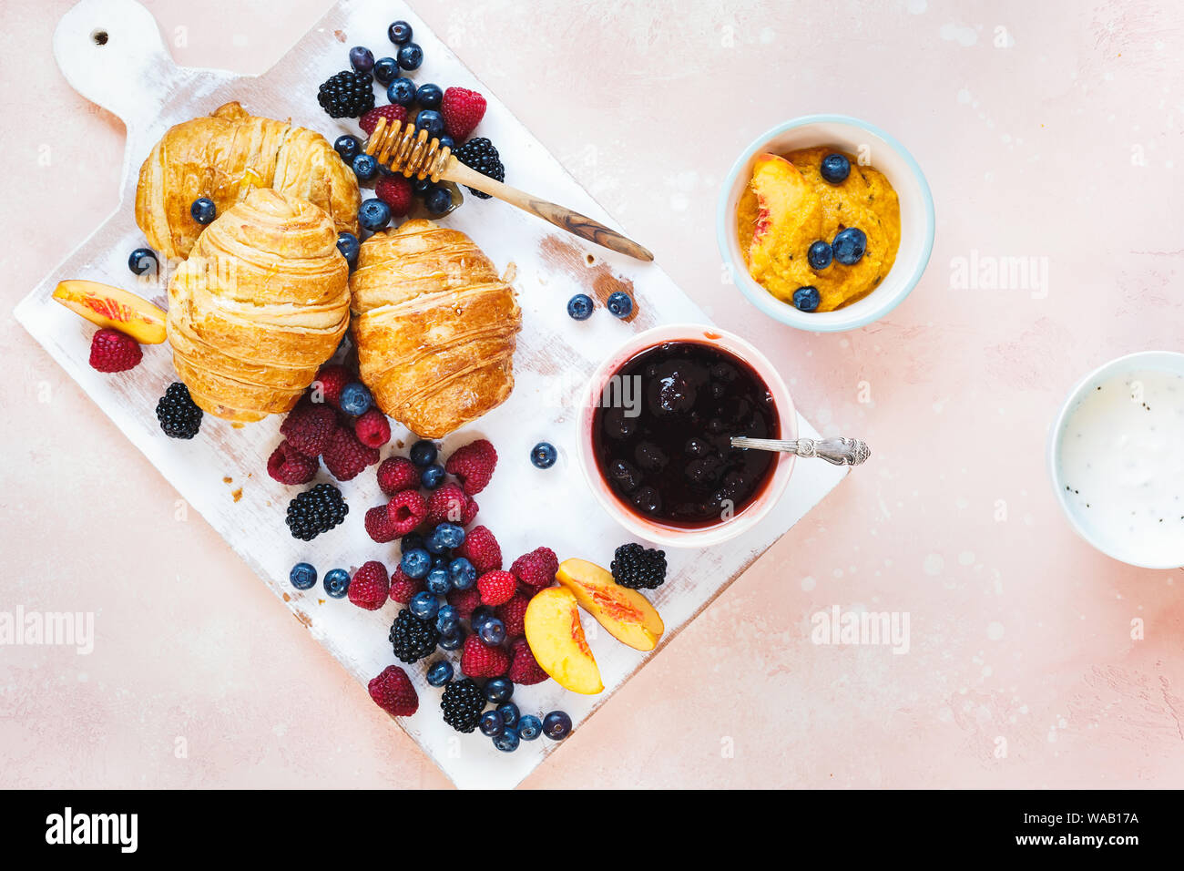 Petit déjeuner fruité. Le petit-déjeuner avec des croissants frais, des fruits et du miel d'été. Vue de dessus, l'espace vide Banque D'Images
