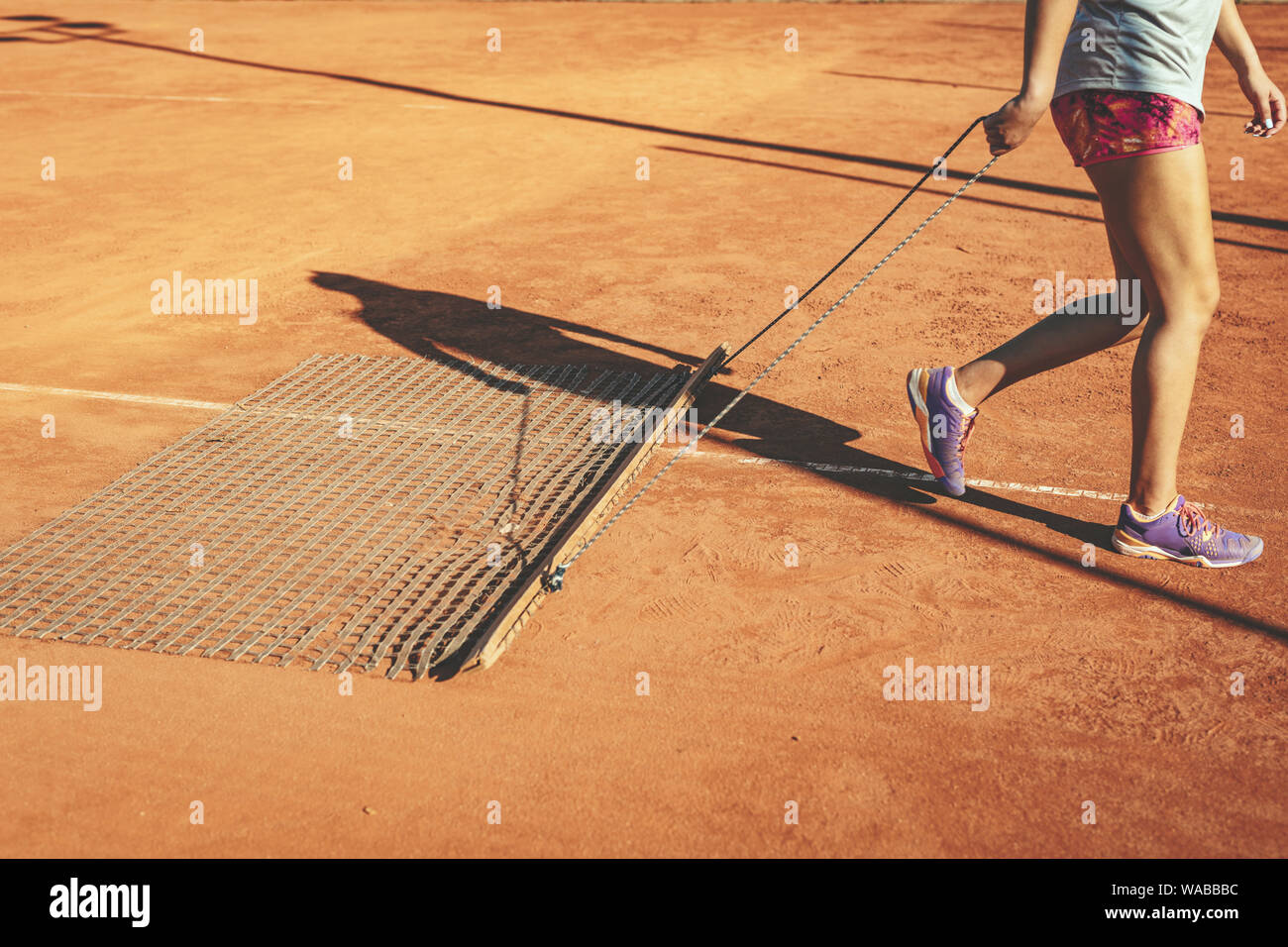 Jeune joueur de tennis féminin sur terre battue rouge récolte de match de tennis sur l'extérieur. Banque D'Images