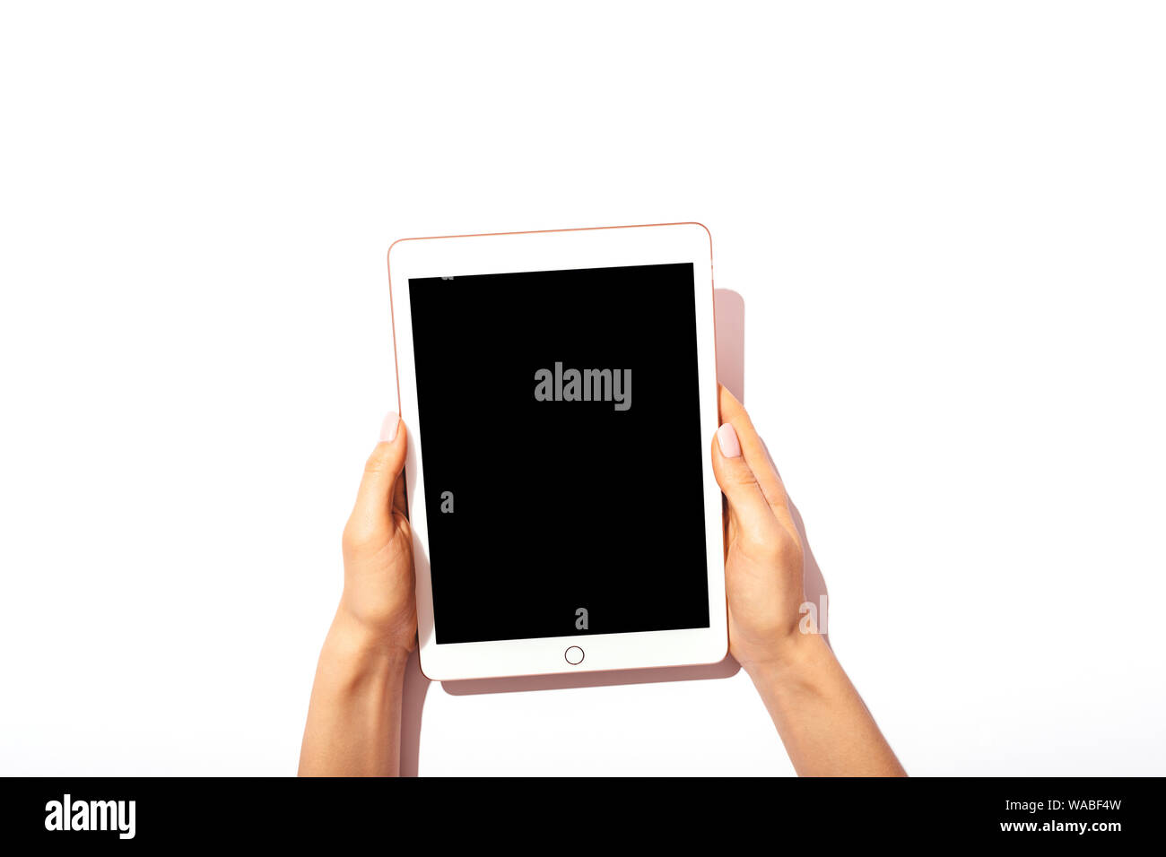 Tablette numérique avec écran vide de femmes avec manucure rose sur fond blanc, vue du dessus. Banque D'Images