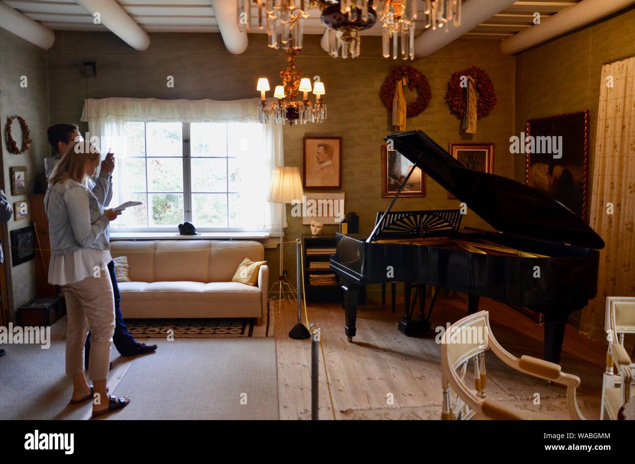 Les visiteurs à la recherche de piano dans la salle de séjour d'Ainola', 'la maison de Jean Sibelius, 287322 Ainolankatu FIN-04400 Järvenpää, Finlande. Banque D'Images