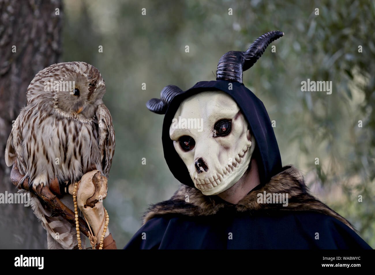 Hameenlinna Finlande 08/17/2019 fête médiévale avec artisan, chevaliers et des amuseurs publics. Un homme avec l'animal cornu et masque de hibou en peluche sur une branche Banque D'Images