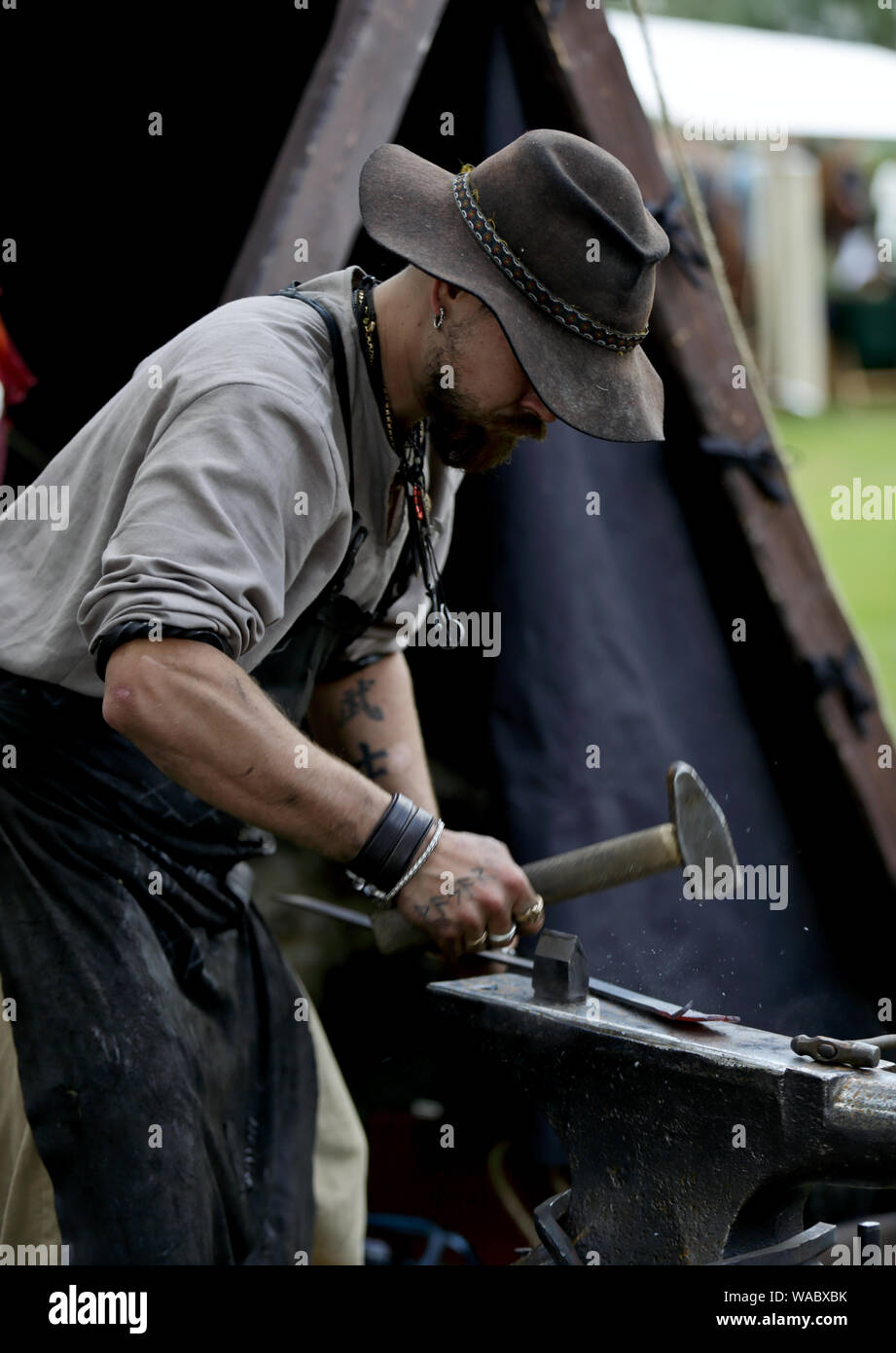 Hameenlinna Finlande 08/17/2019 fête médiévale avec artisan, chevaliers et des amuseurs publics. Un forgeron travailler avec un marteau Banque D'Images