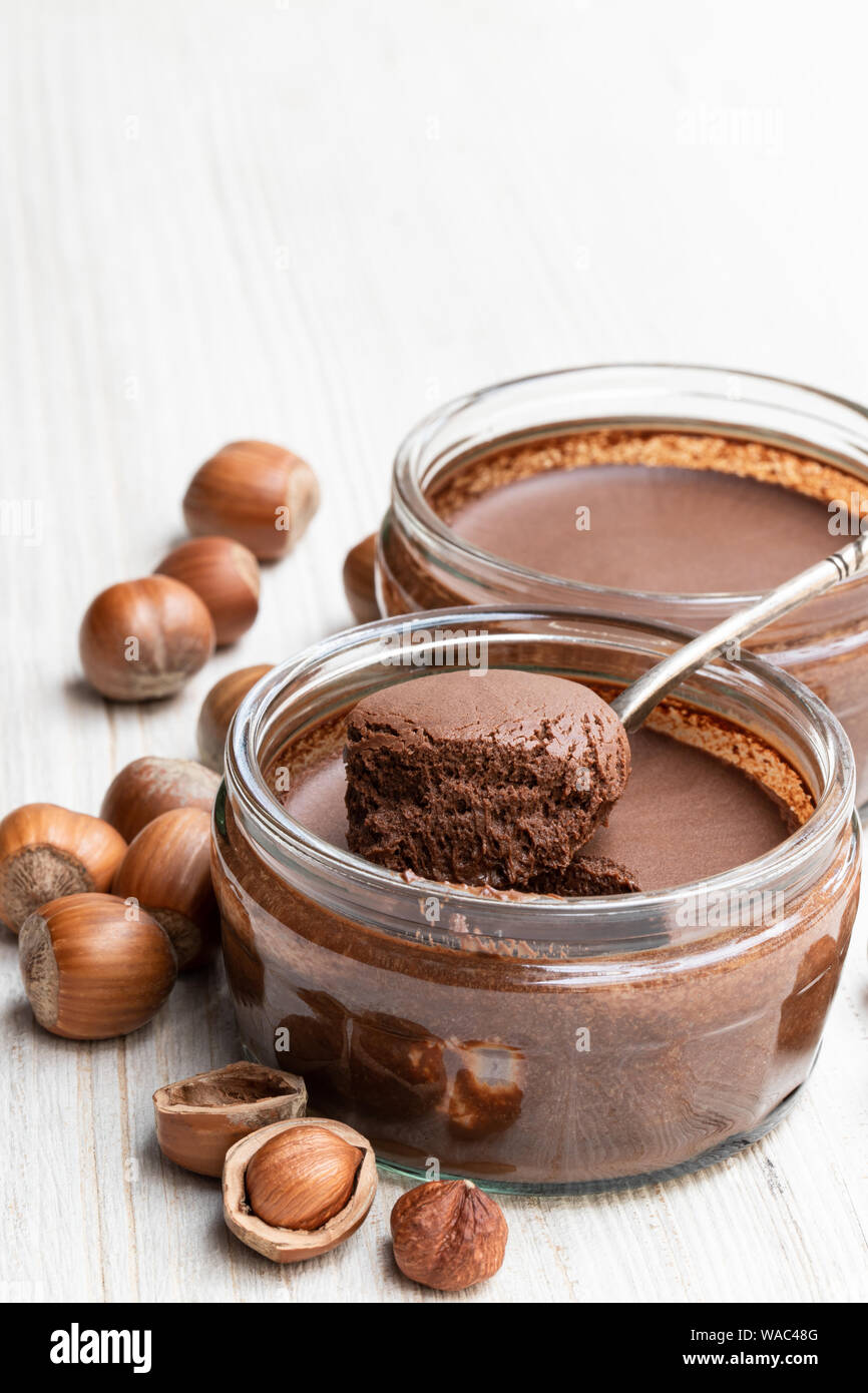 Praliné noisette au chocolat maison dans un bocal en verre sur la table en bois blanc Banque D'Images