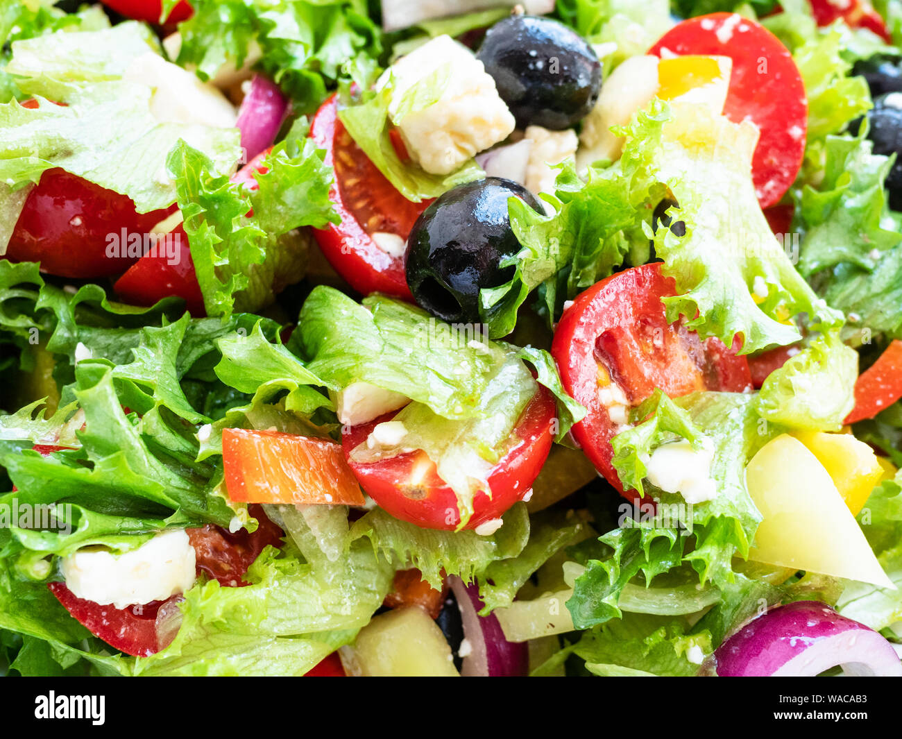 Salade grecque de légumes frais, fromage feta et olives noires habillées par l'huile d'olive close-up Banque D'Images
