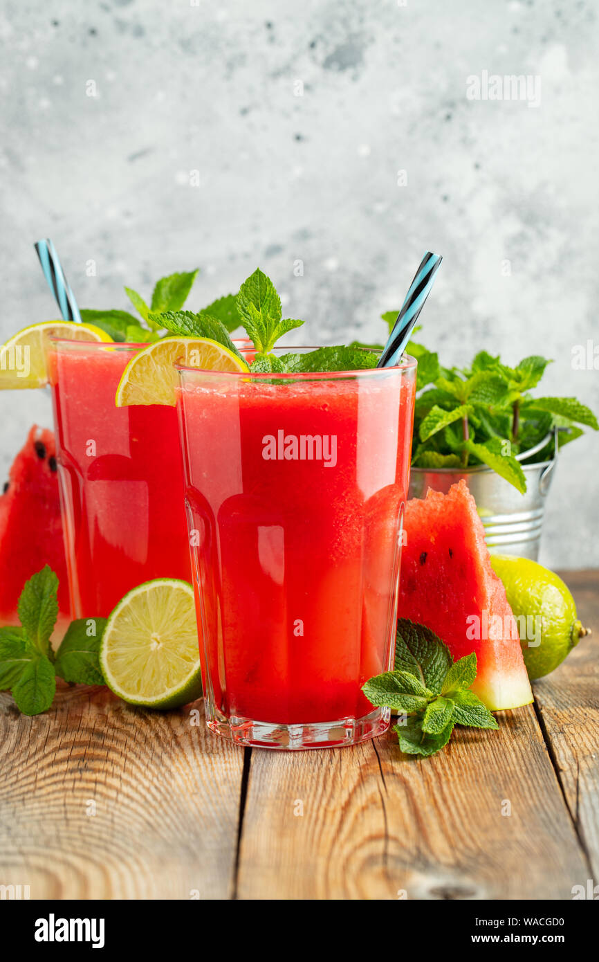 La sauce au melon d'eau avec citron vert et menthe, une boisson rafraîchissante d'été dans de grands verres sur fond bleu clair. Smoothie doux et froid Banque D'Images