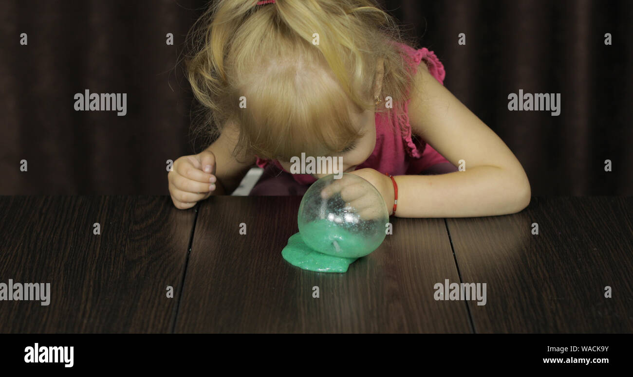 Enfant s'amusant making green slime. Enfant jouant avec jouet Slime fait  main. Kid Funny Girl. Blowing bubble via la paille. Bizarrement  satisfaisant de slime bleu pur plaisir et stress relief Photo Stock -