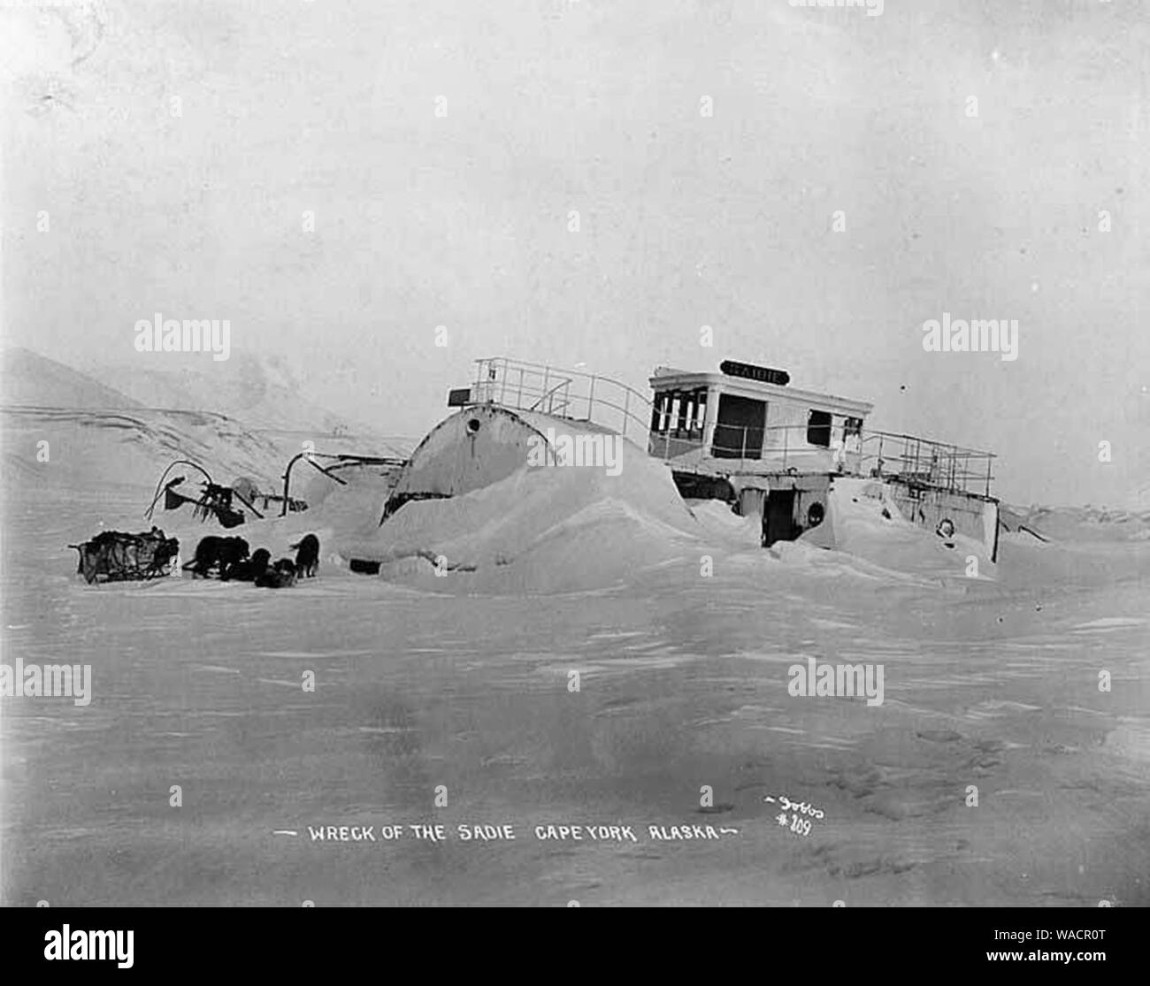 L'équipe de chien de traîneau à côté de l'épave du vapeur dans SADIE la glace et la neige, Cape York, l'Alaska, entre 1902 et 1912 (AL CA 2414). Banque D'Images