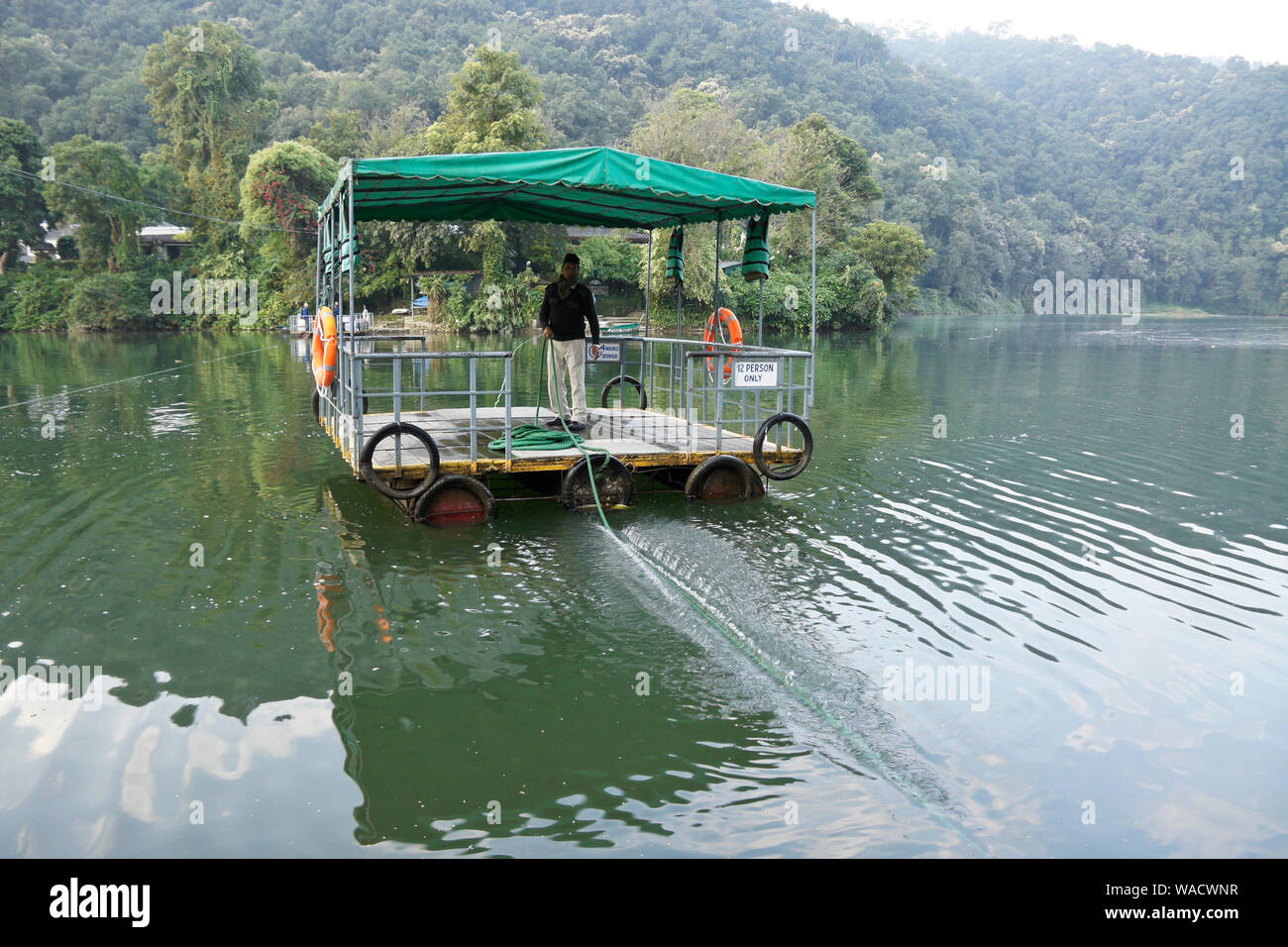 Radeau tirées à la main (passagers) sur le Lac Phewa (Lac Fewa) Canal à queue de poisson (chambre) Lodge sur une péninsule, Pokhara, Népal Banque D'Images