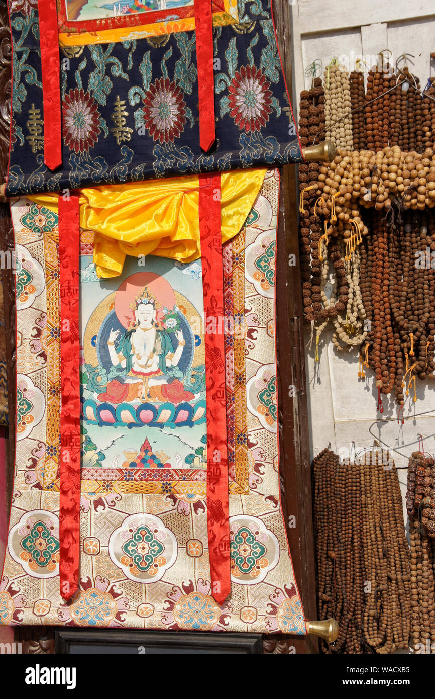 Thangkas bouddhistes tibétaines (tentures) et chapelet en vente en magasin à Boudhanath, Vallée de Katmandou, Népal Banque D'Images