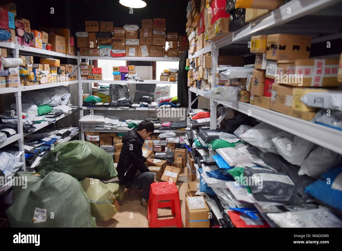 --FILE--Un travailleur chinois sortes à la diffusion massive des parcelles, dont la plupart sont des célibataires de jour des achats en ligne, à une station d'entraînement à Changsha city, le centr Banque D'Images