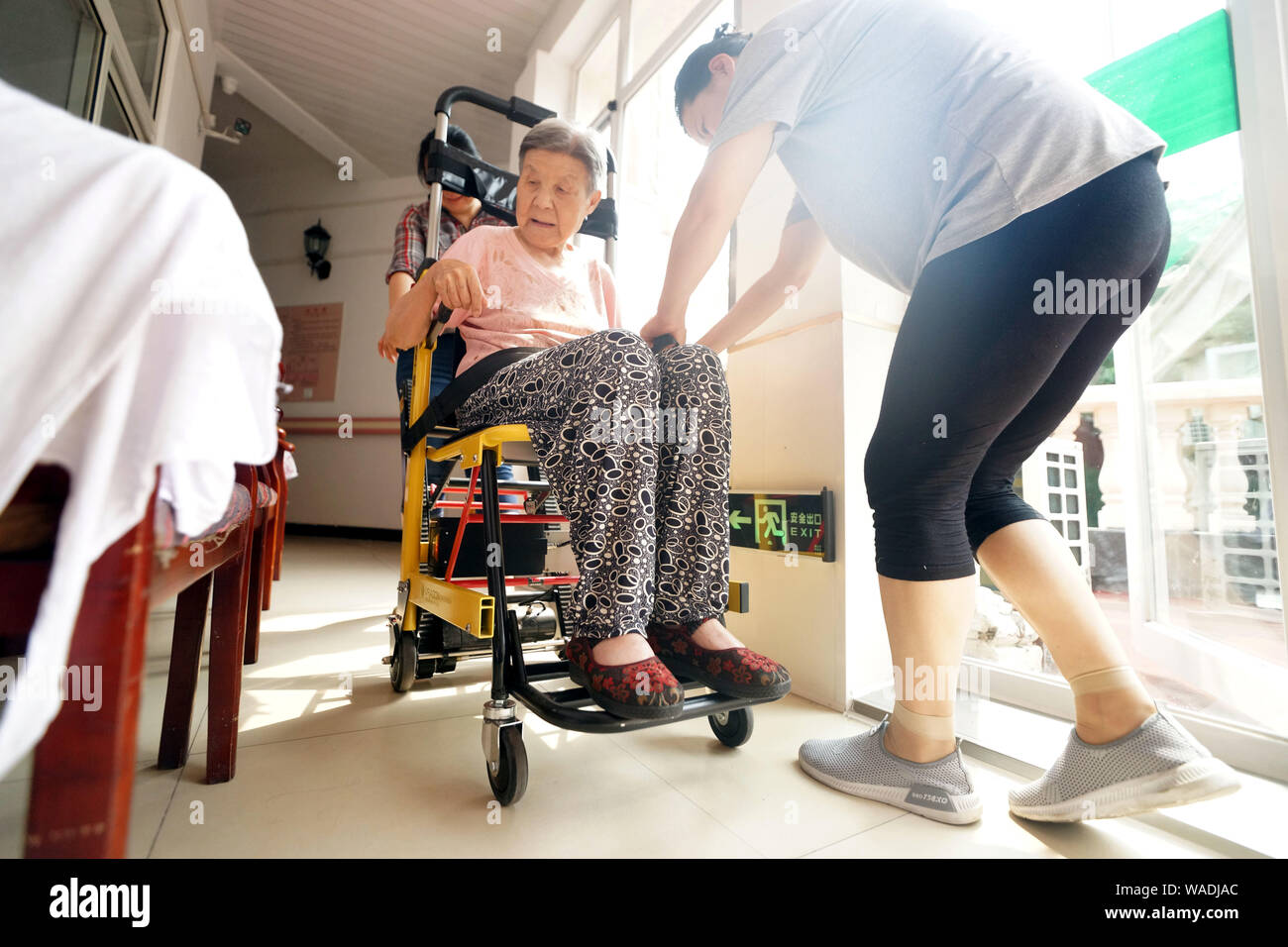 --FILE--travailleurs chinois s'occuper d'une vieille femme au foyer de soins à Tianjin, Chine, 26 juin 2019. Même si la Chine a augmenté sa durée de vie moyenne sp Banque D'Images