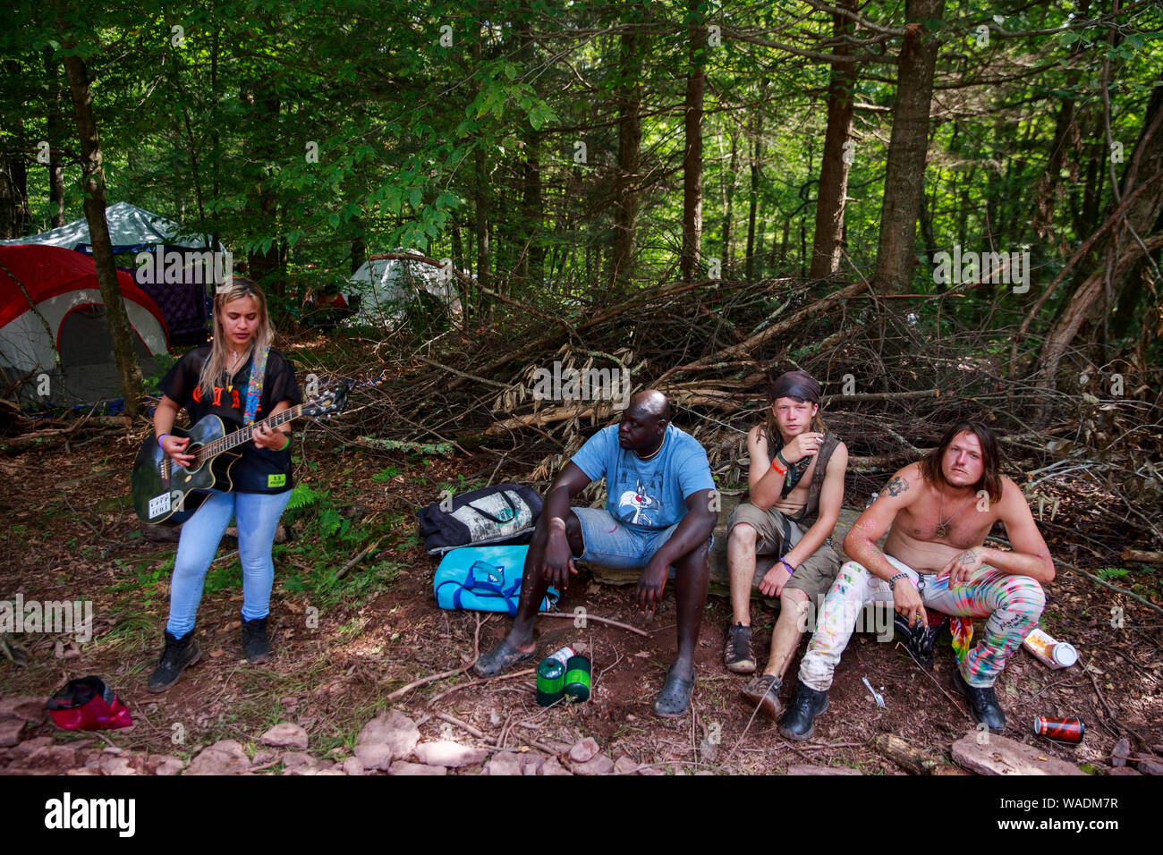 Béthel, United States. Août 18, 2019. Une femme joue de la guitare près du distributeur stand tandis que d'autres participants à l'écoute au cours de la réunion de la route Yasgur Max Yasgur's farm à pendant les célébrations du 50e anniversaire de Woodstock près de Bethel. Organisateur de Woodstock Michael Lang, l'événement a été annulé mais anniversaire les activités ont continué au Arrowhead Ranch, Bethel Woods (le site de l'original Woodstock en 1969), Hector's Inn, et Yasgur's Farm. Credit : SOPA/Alamy Images Limited Live News Banque D'Images