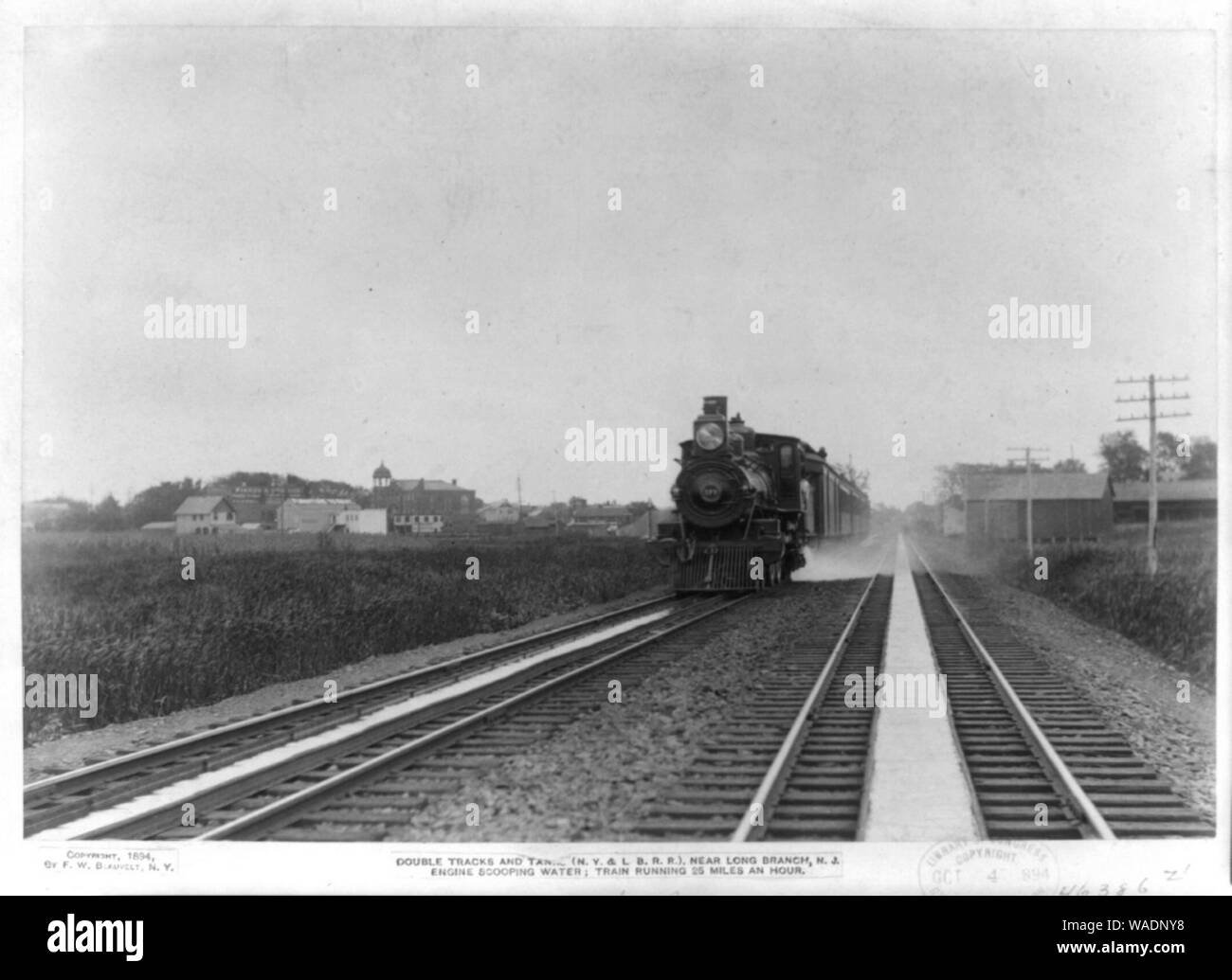 Voies doubles et des réservoirs (N. Y. & L., B. R. R.) près de Long Branch, N. J. scooping moteur l'eau ; la circulation du train, 25 milles à l'heure. Banque D'Images