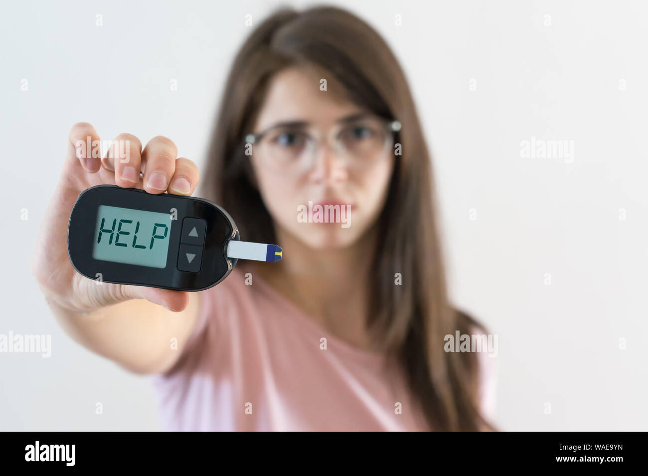 Fille avec glucosometer montre le diabète juvénile que demander de l'aide parce que la glycémie est élevée Banque D'Images