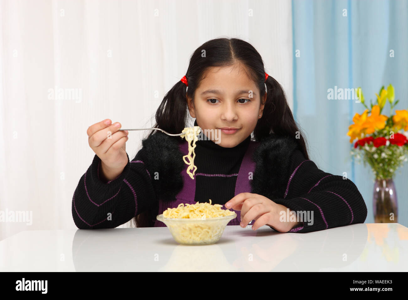 Girl eating noodles Banque D'Images