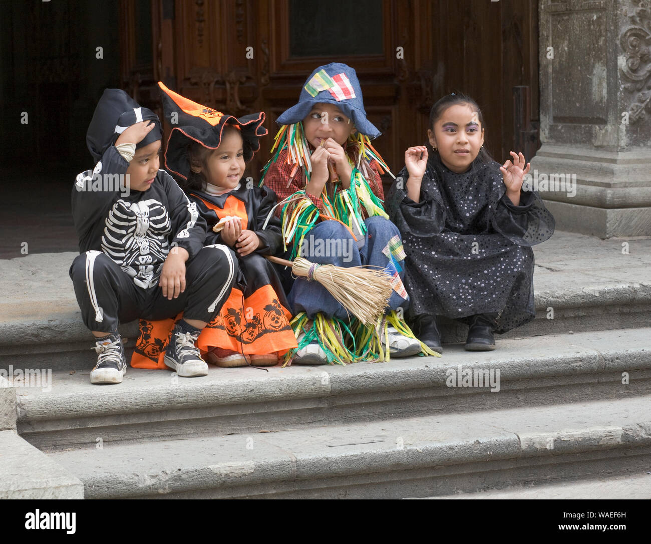 Mignon enfants mexicains dans Halloween costumes assis sur les marches de la cathédrale, la Ville d'Oaxaca, Oaxaca, Mexique vacances locales et festivals Banque D'Images