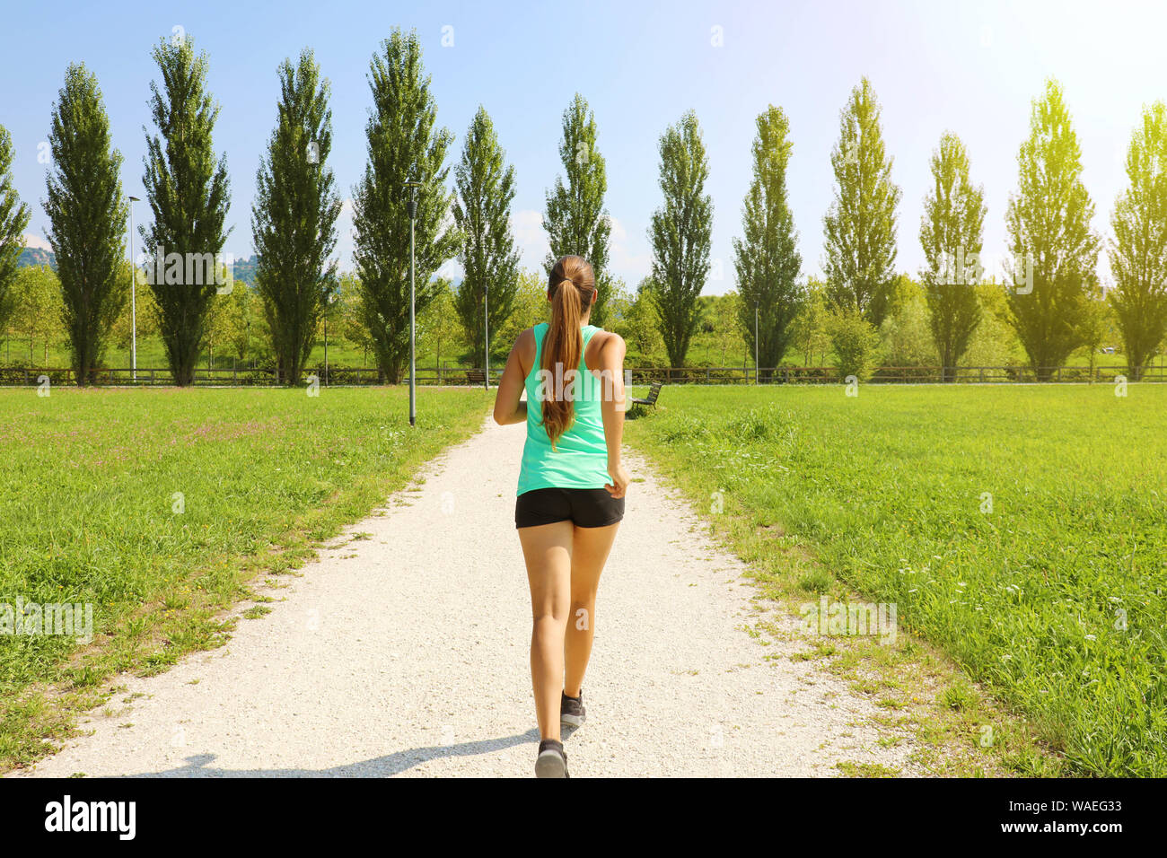 Young woman running in park. Fitness petite fille jogging en parc. Vue  arrière de fille sportive s'exécutant sur voie Photo Stock - Alamy