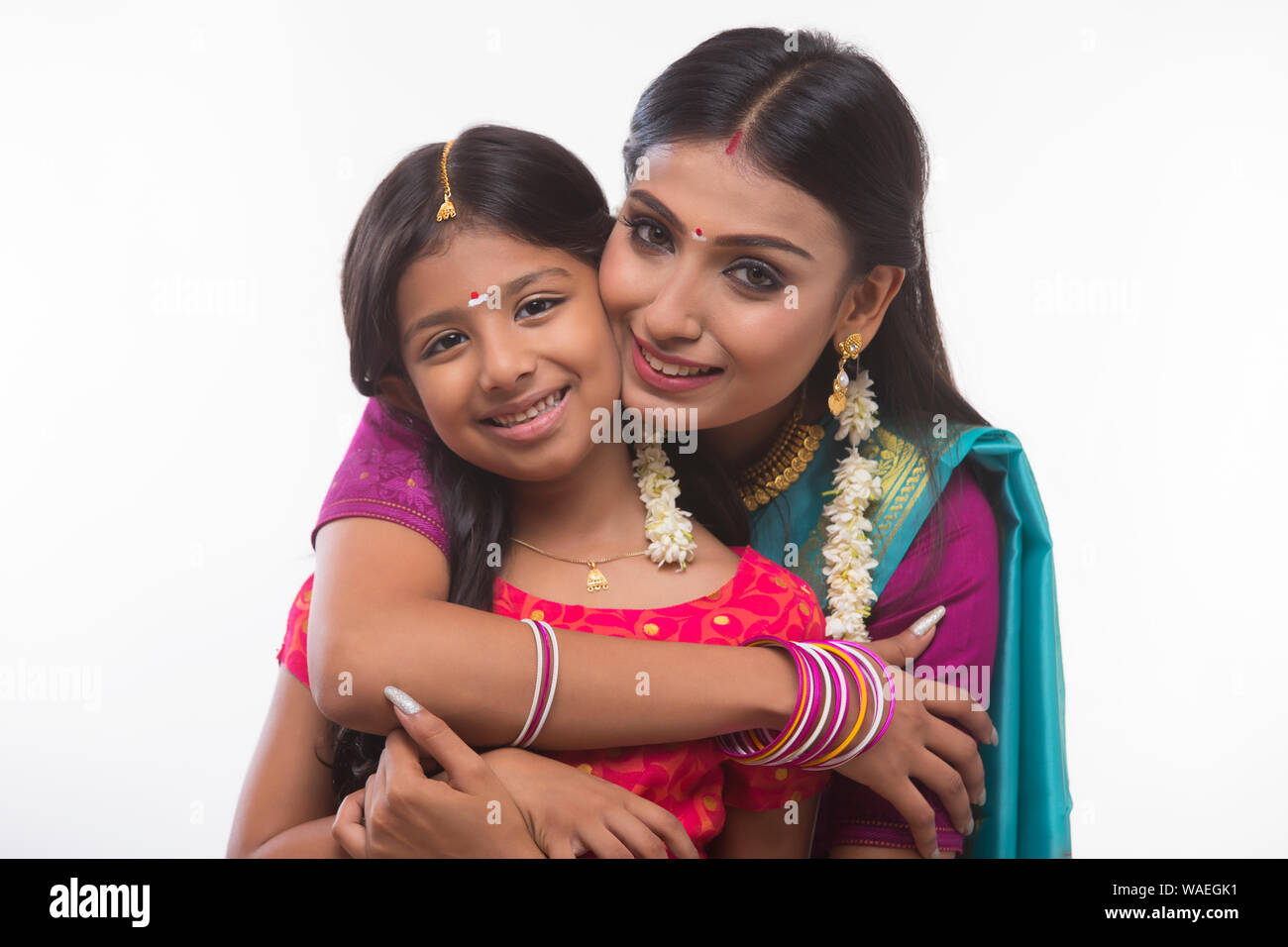 South Indian woman hugging her daughter and smiling at the camera Banque D'Images
