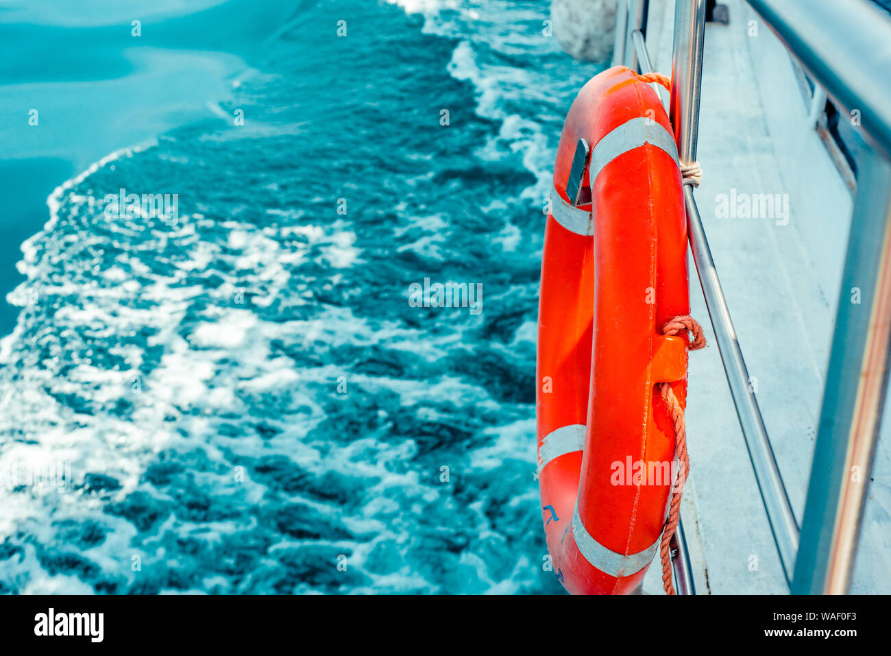 Bouée rouge sur la surface de la mer avec garde-corps de navire. Banque D'Images